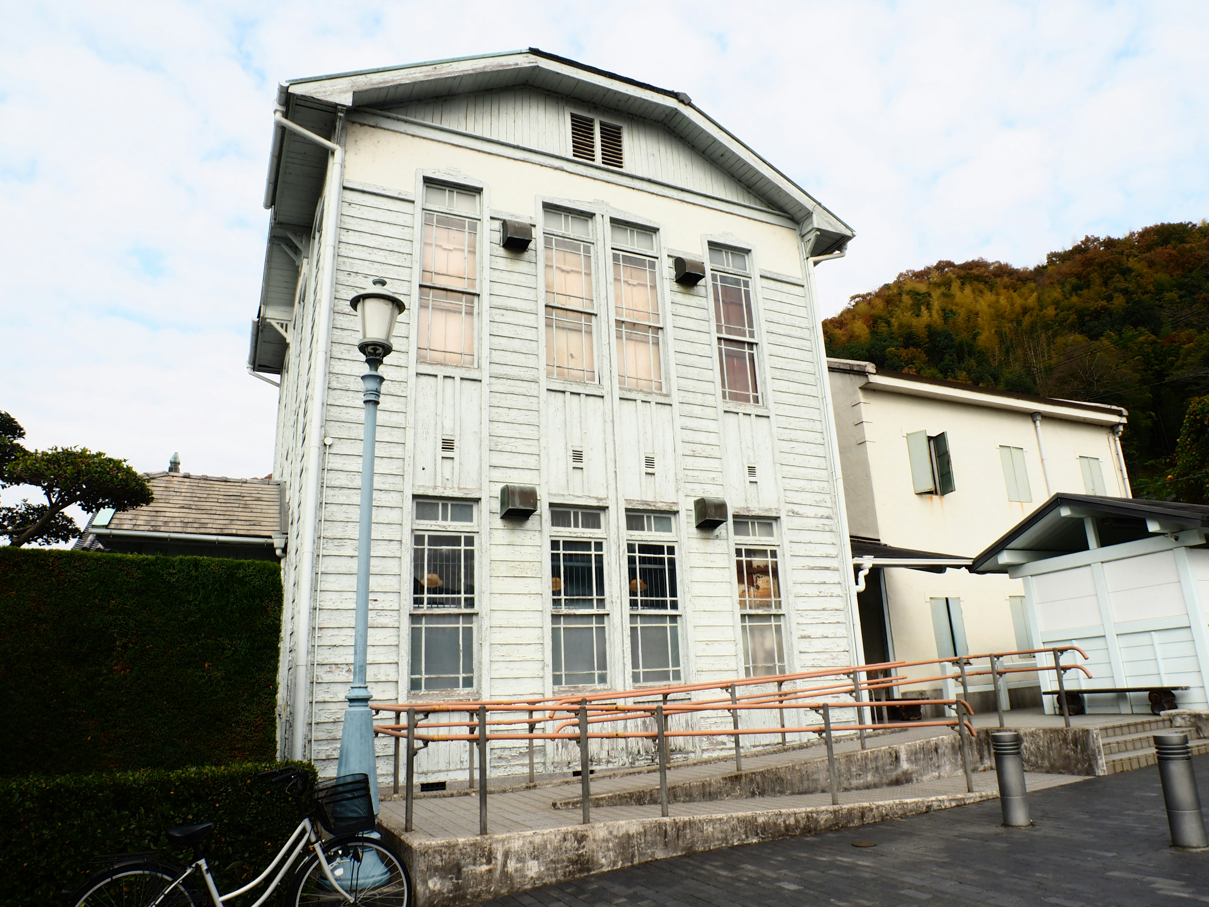 Historisches Gebäude mit weißer Fassade und umliegendem Grün