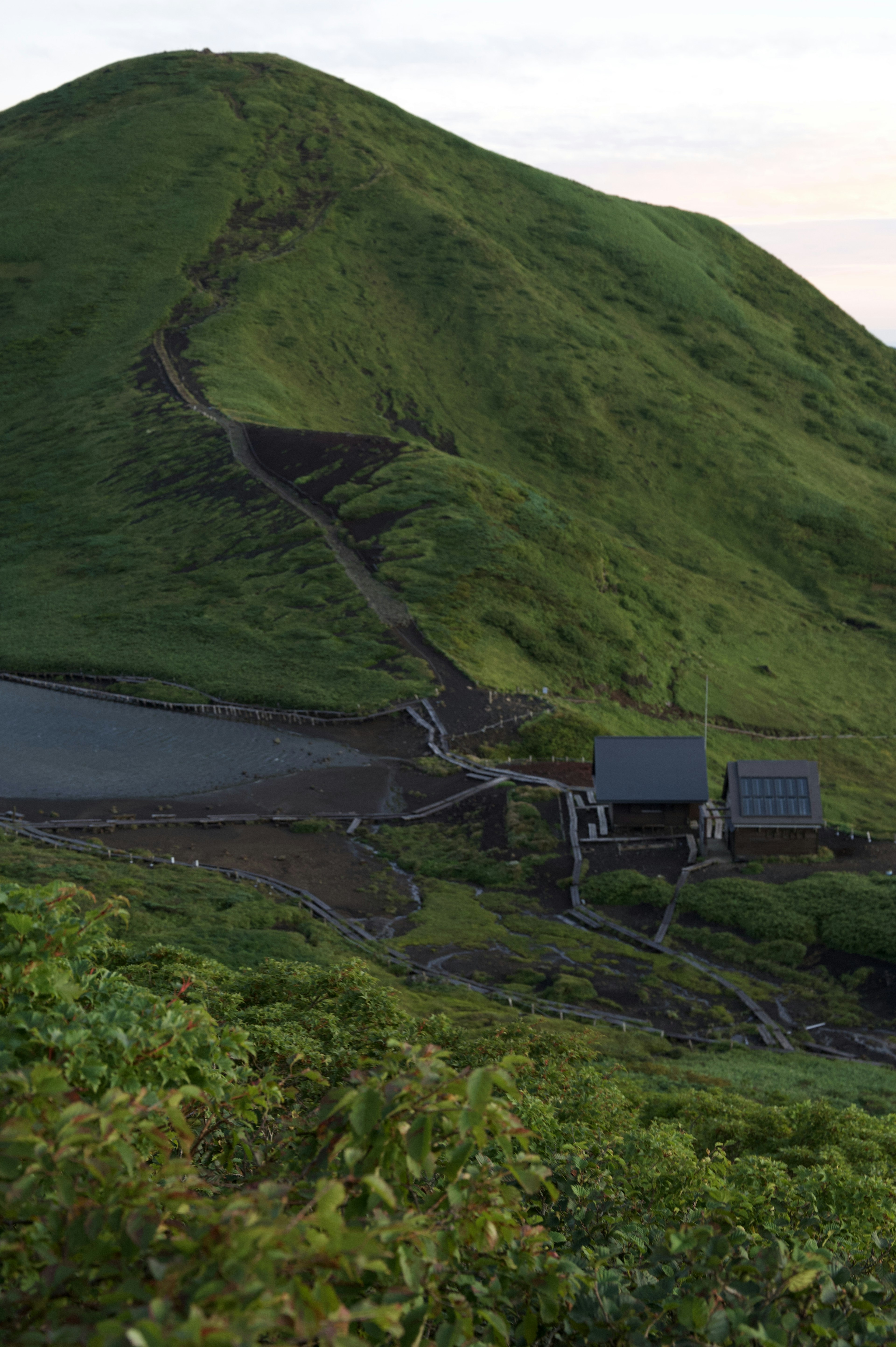 緑の山と小屋の風景 山の斜面に沿った小道