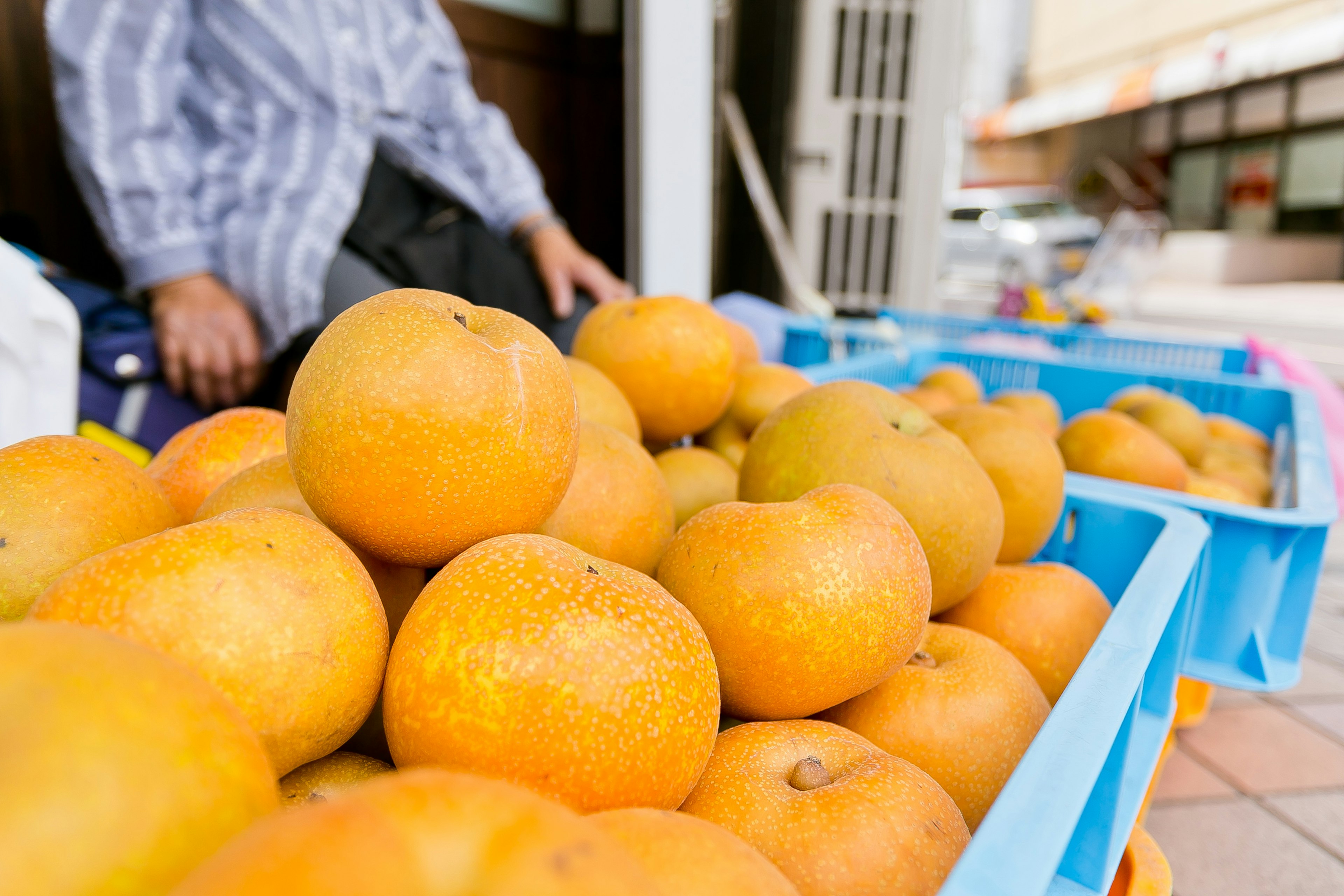 Un étalage d'oranges fraîches avec une main d'homme en arrière-plan