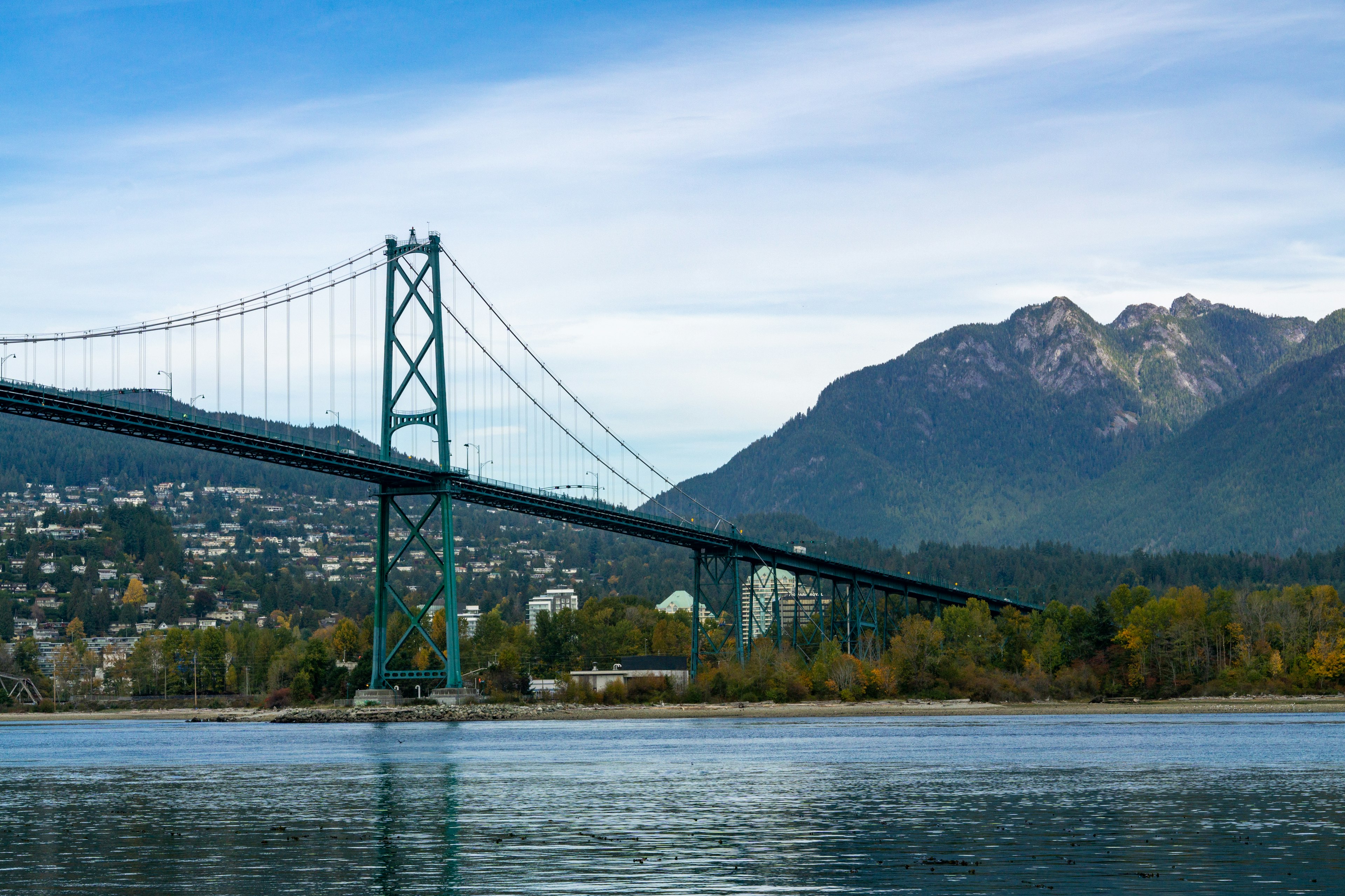 ทิวทัศน์ของสะพานแขวนสีน้ำเงินพร้อมภูเขาในพื้นหลัง