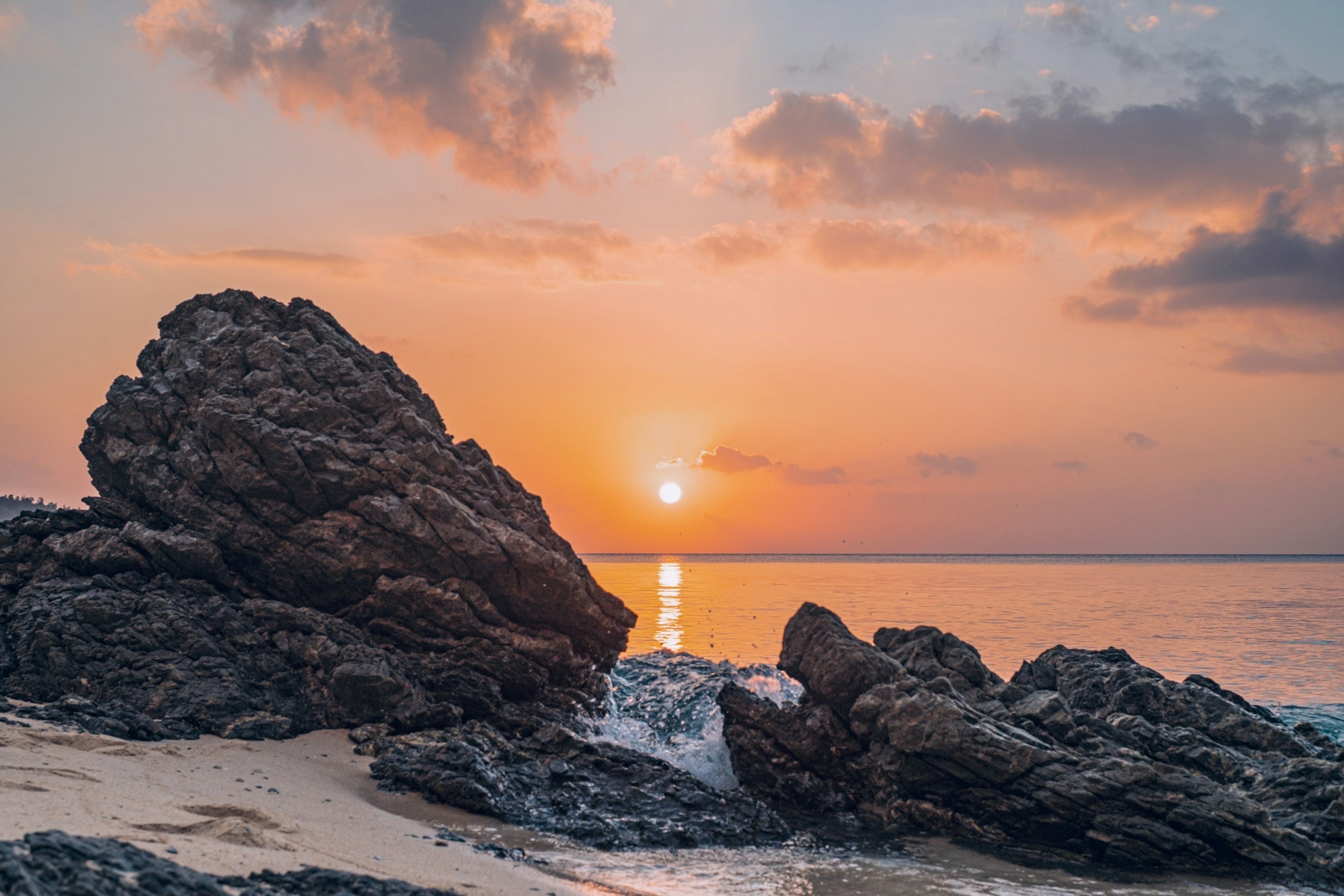 美丽的海上日落与前景中的岩石