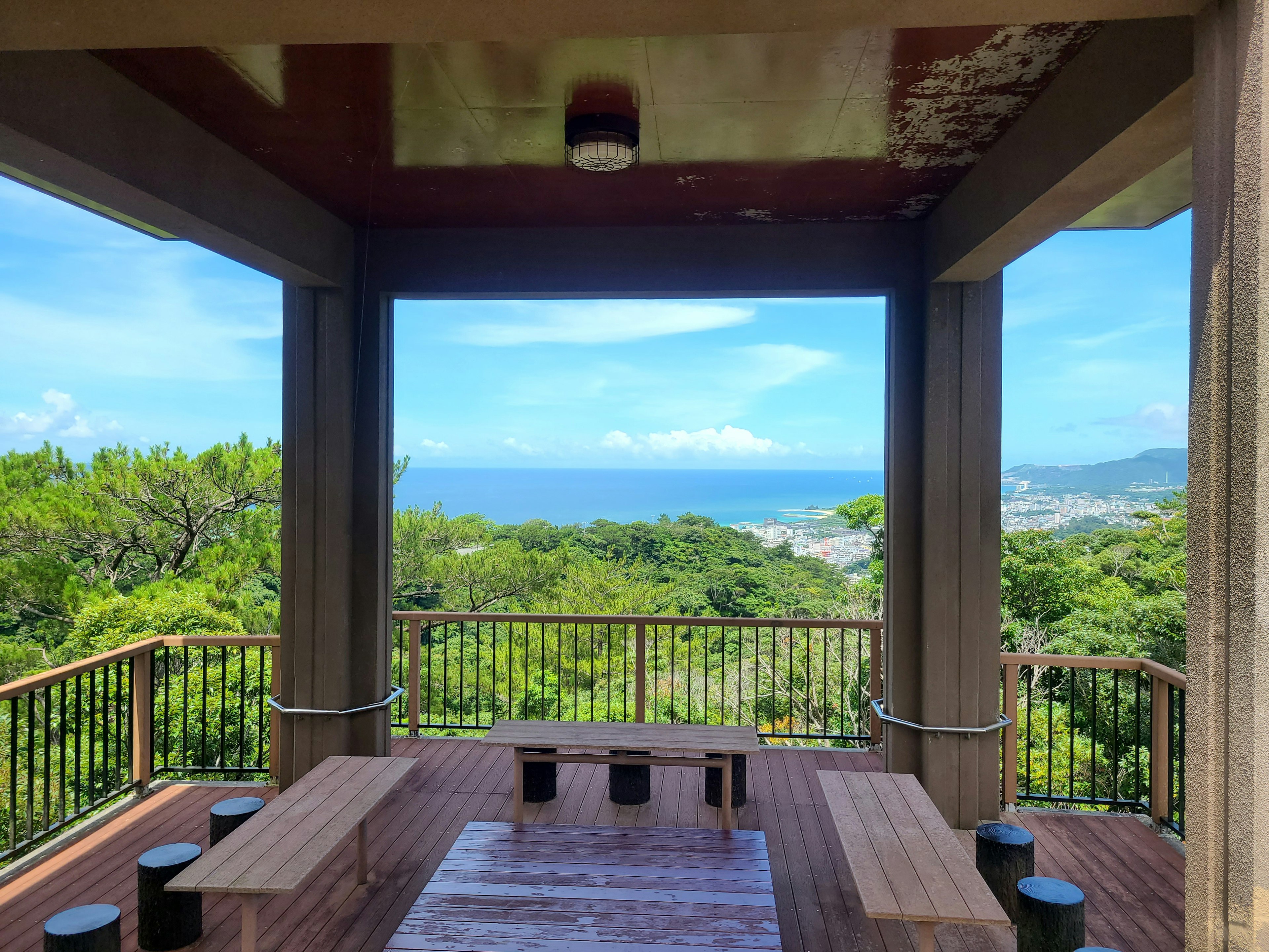 Outdoor seating area with wooden table and chairs overlooking the ocean