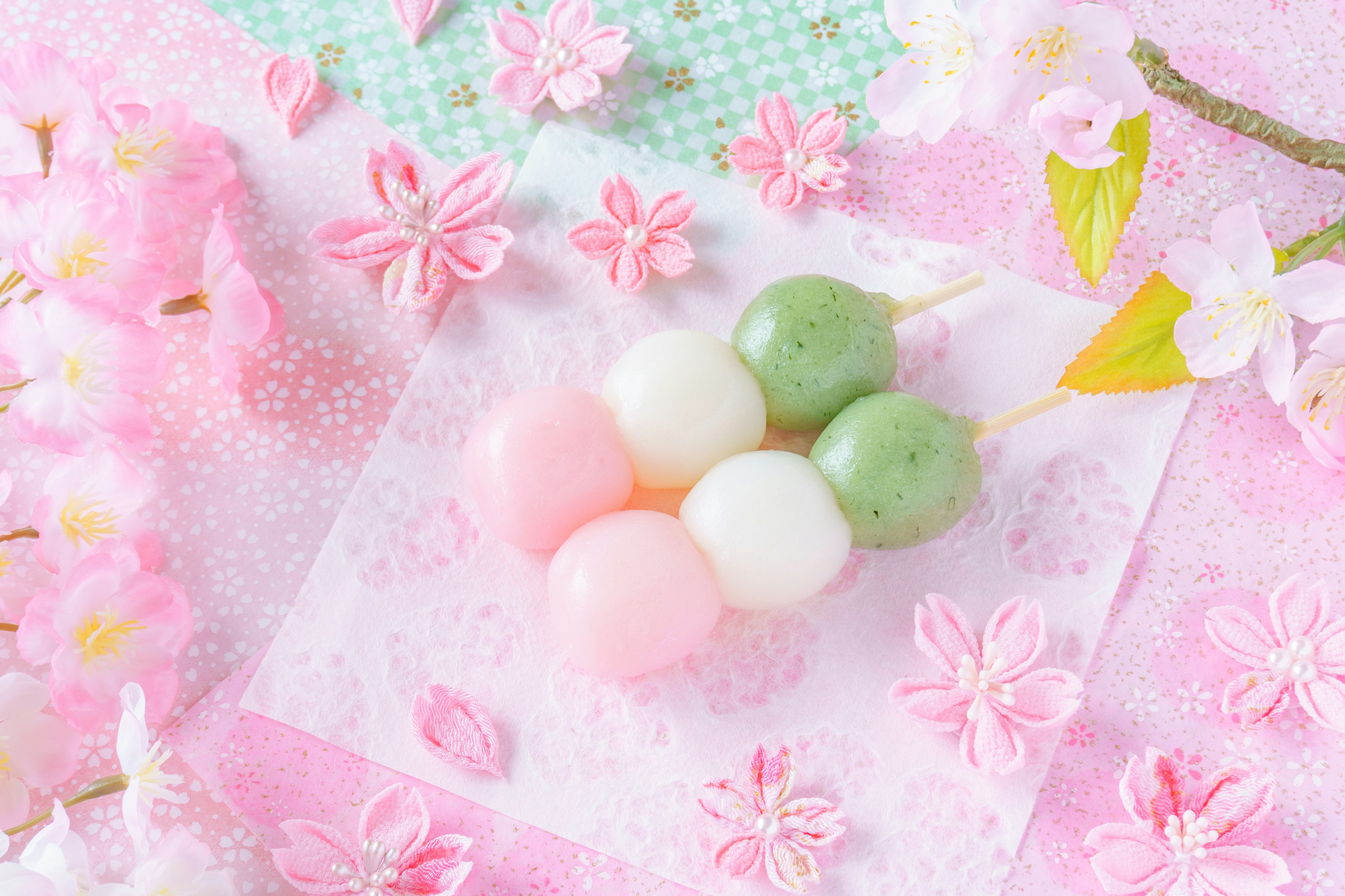 Schöne Anordnung eines Frühlingsdesserts mit sanft gefärbtem Dango und Kirschblüten