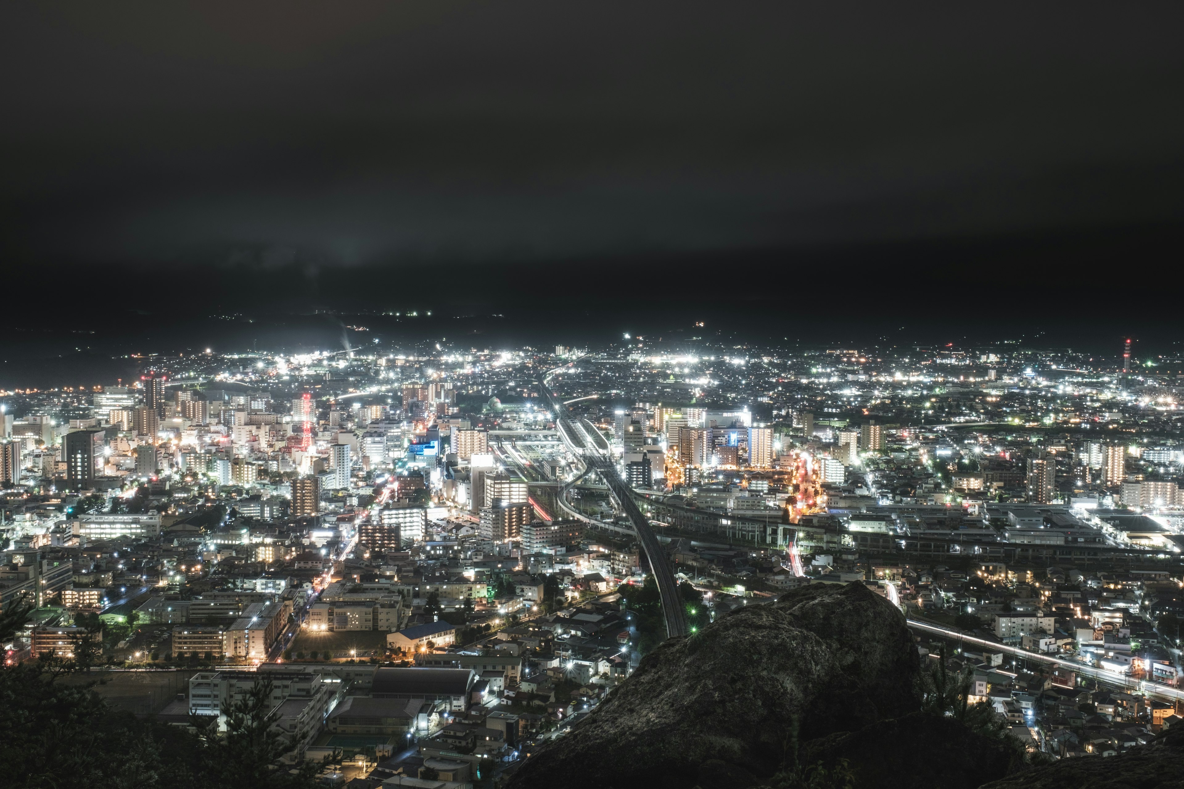 Vista panoramica di una città di notte con luci di edifici luminosi e una ruota panoramica in lontananza