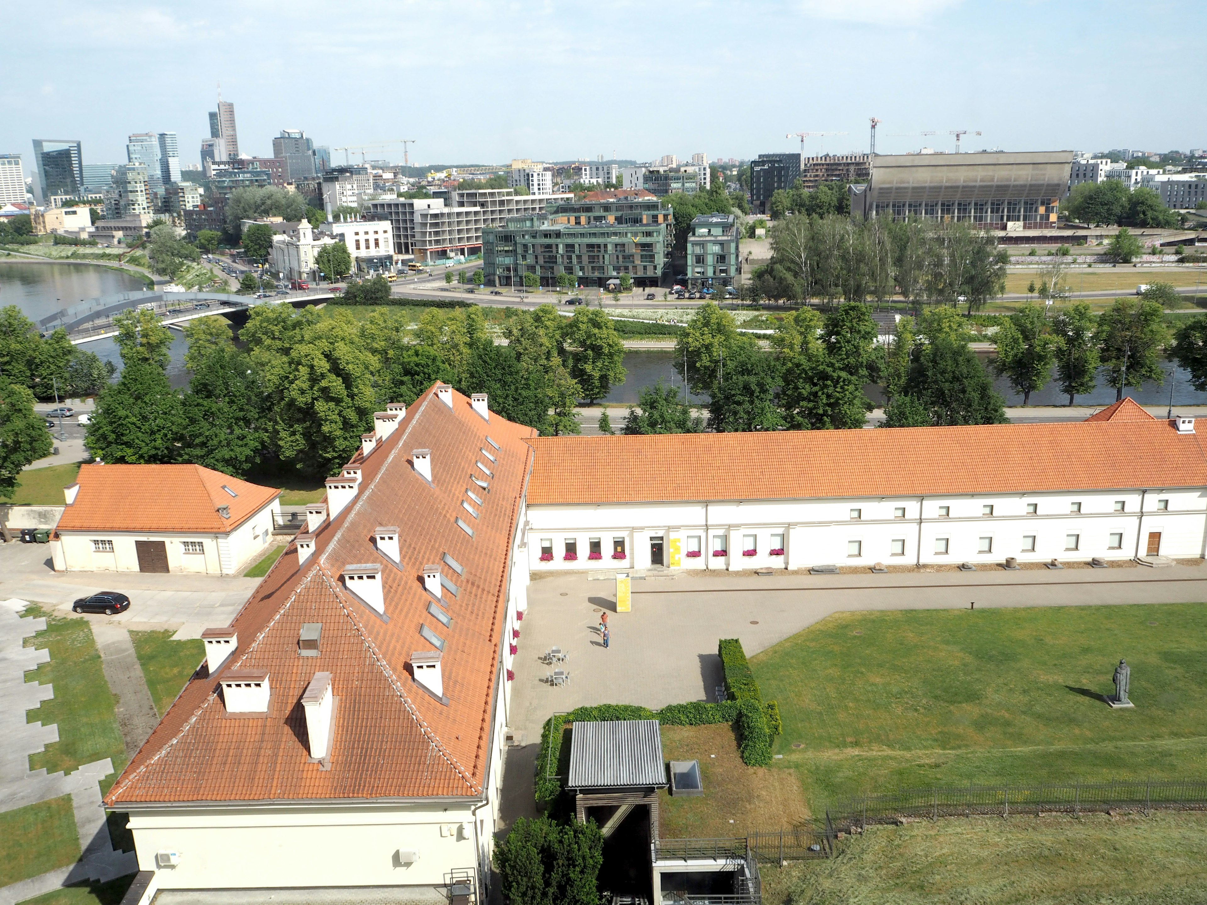 Aerial view of a historic building surrounded by greenery and a river