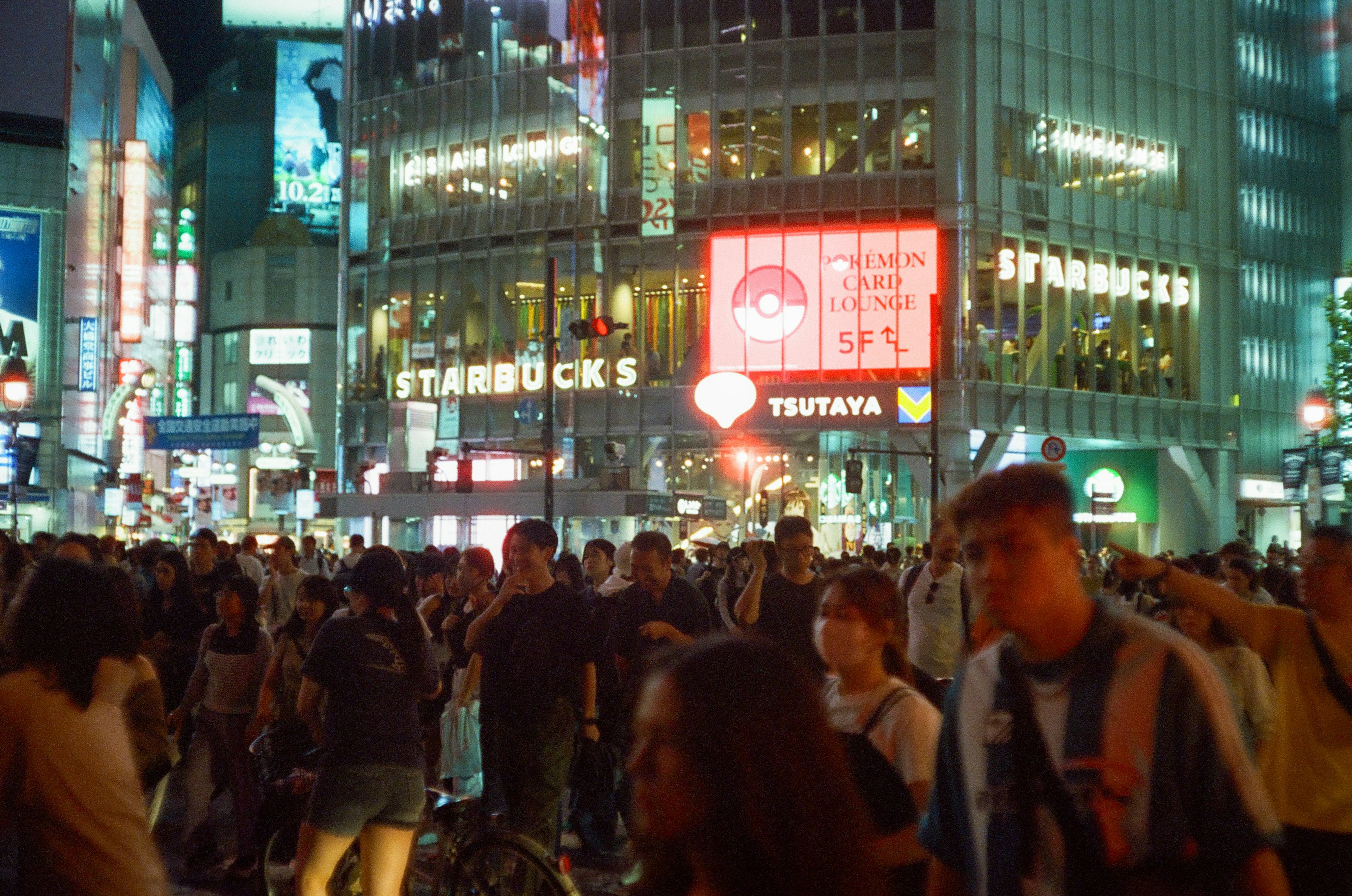 渋谷の交差点で賑わう人々とスターバックスの看板