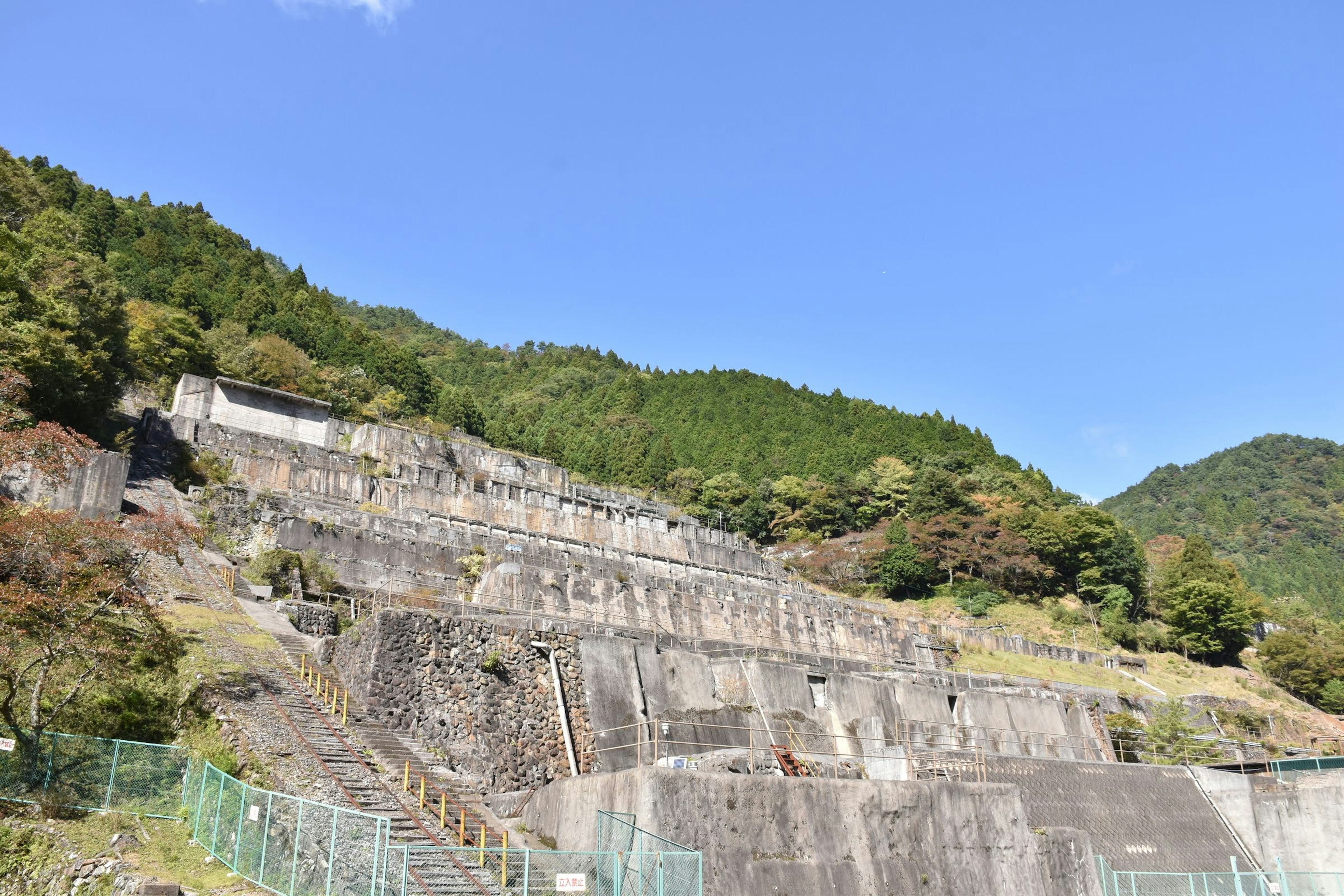 Concrete structure against a mountain backdrop and blue sky