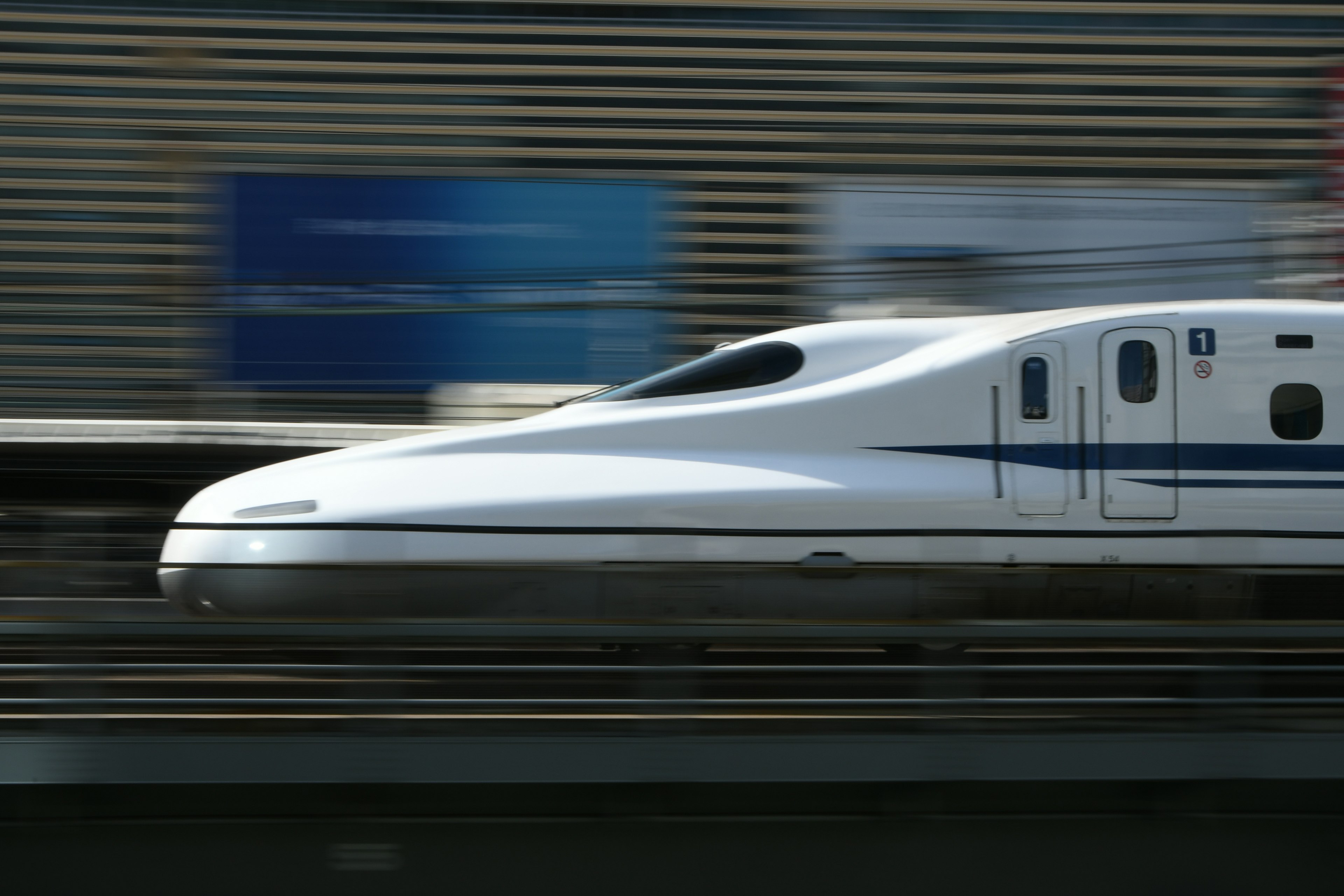 Shinkansen melaju cepat melewati latar belakang kabur