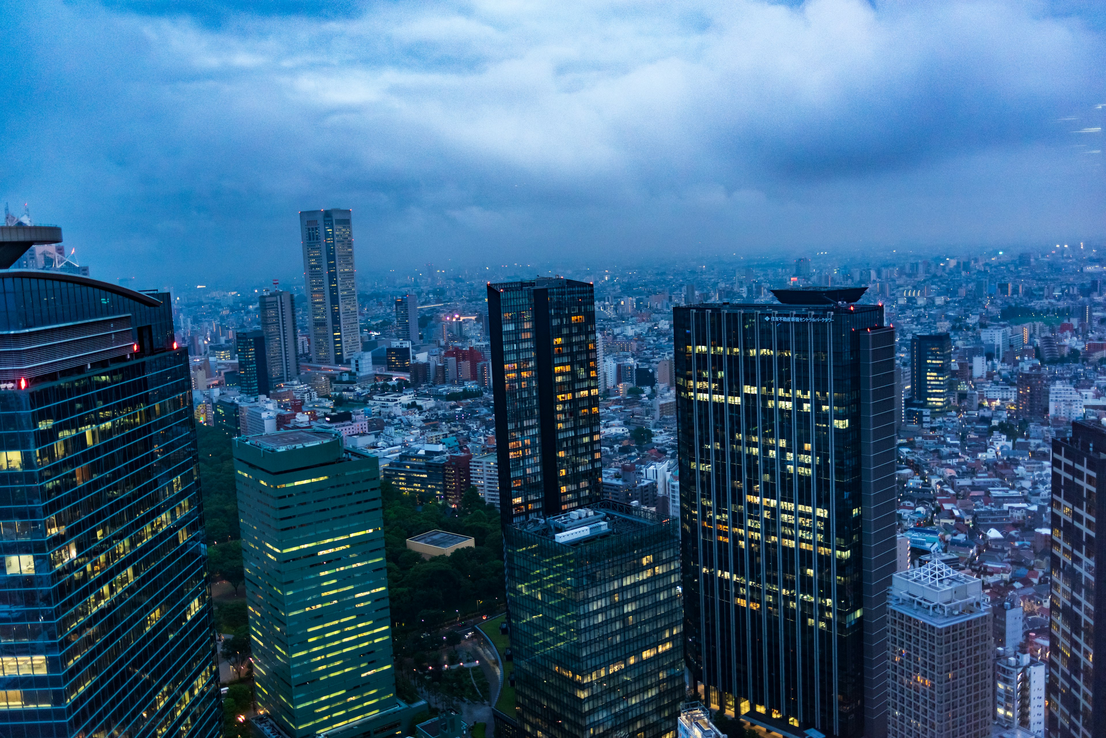 Night view of Tokyo's skyscrapers with a blue sky and clouds