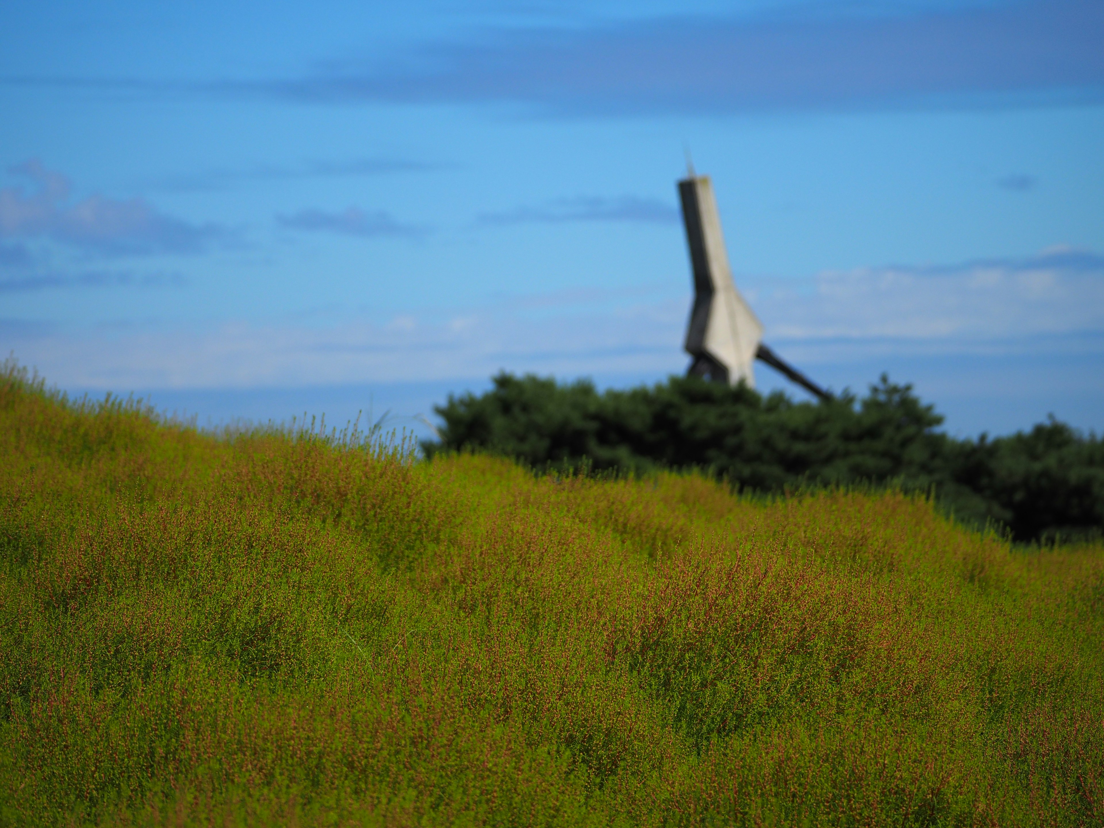 Concrete structure under blue sky with grassy hill