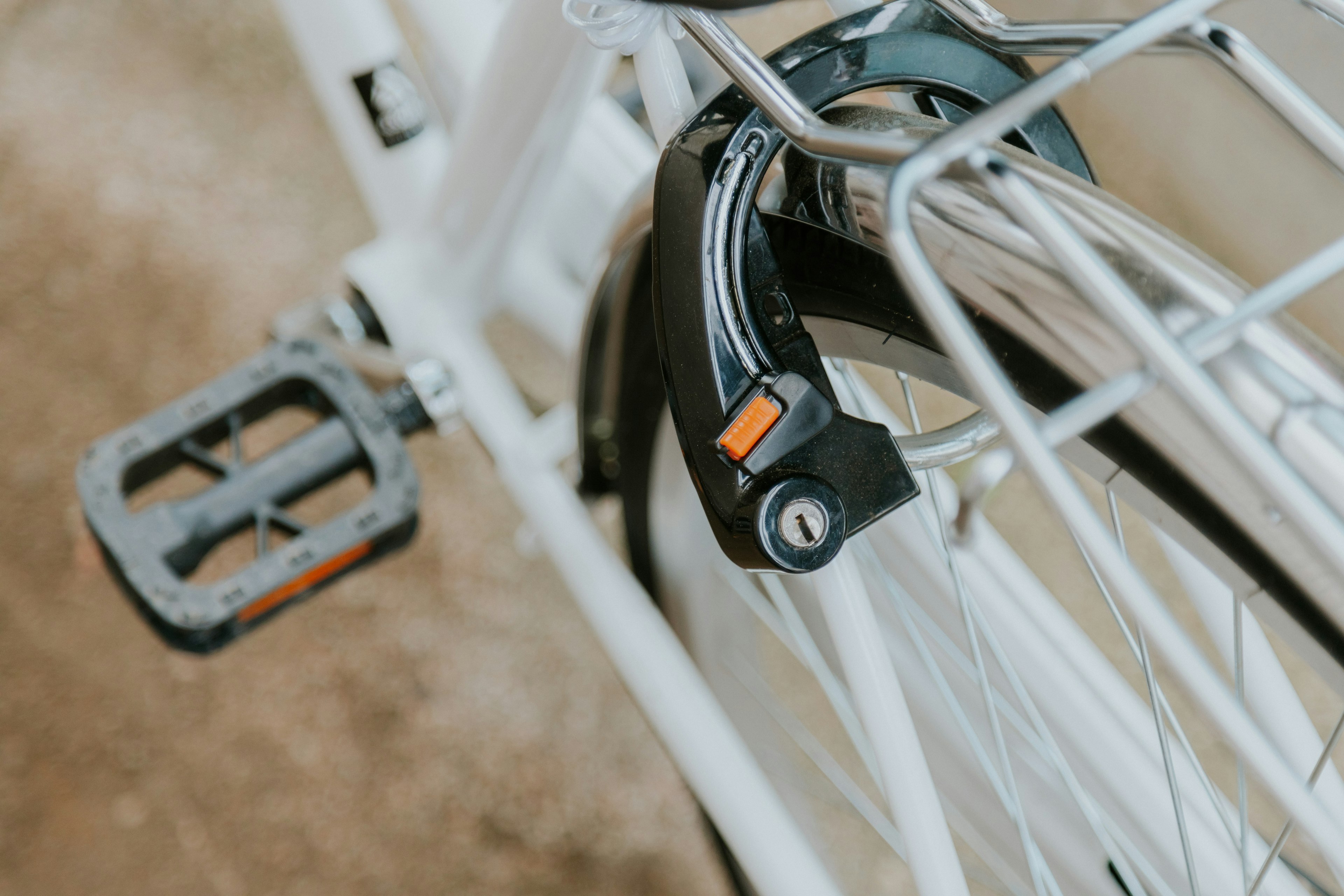 Close-up image of a white bicycle pedal and lock