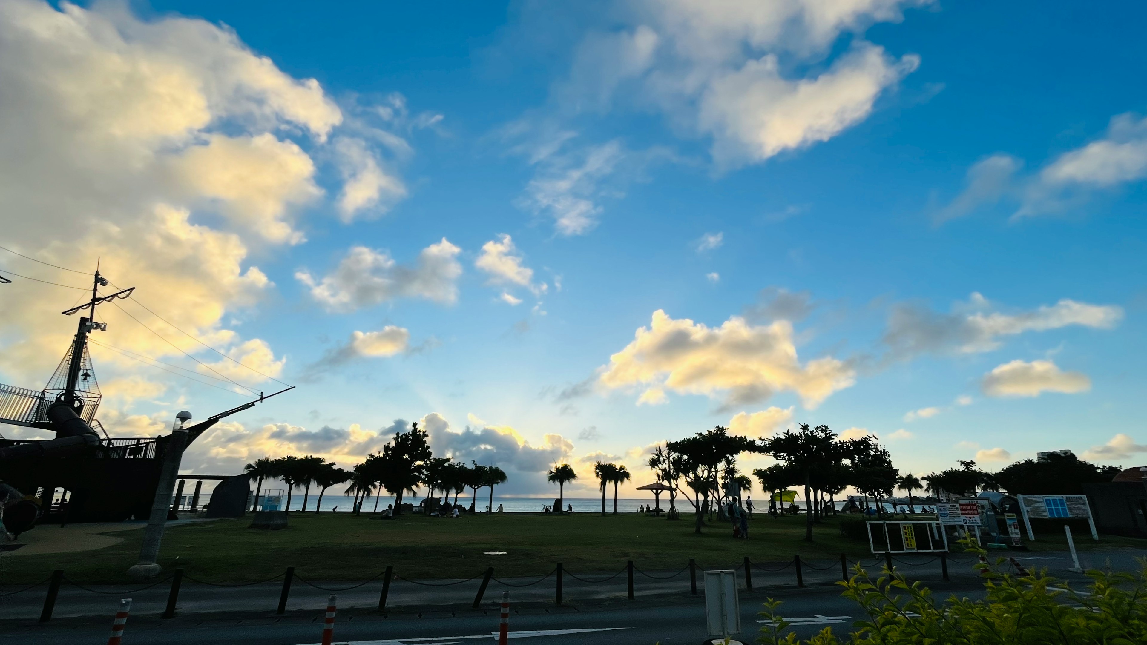 青空と雲が広がる風景に古い船と木々が映える