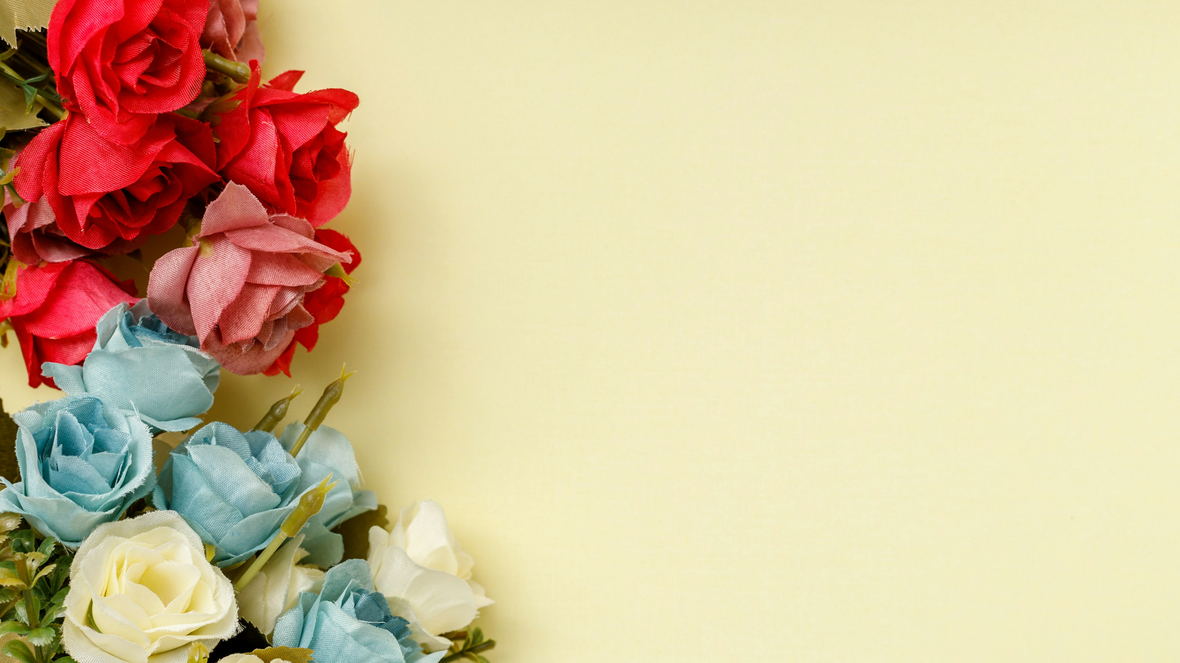 Colorful flowers arranged in one corner on a yellow background