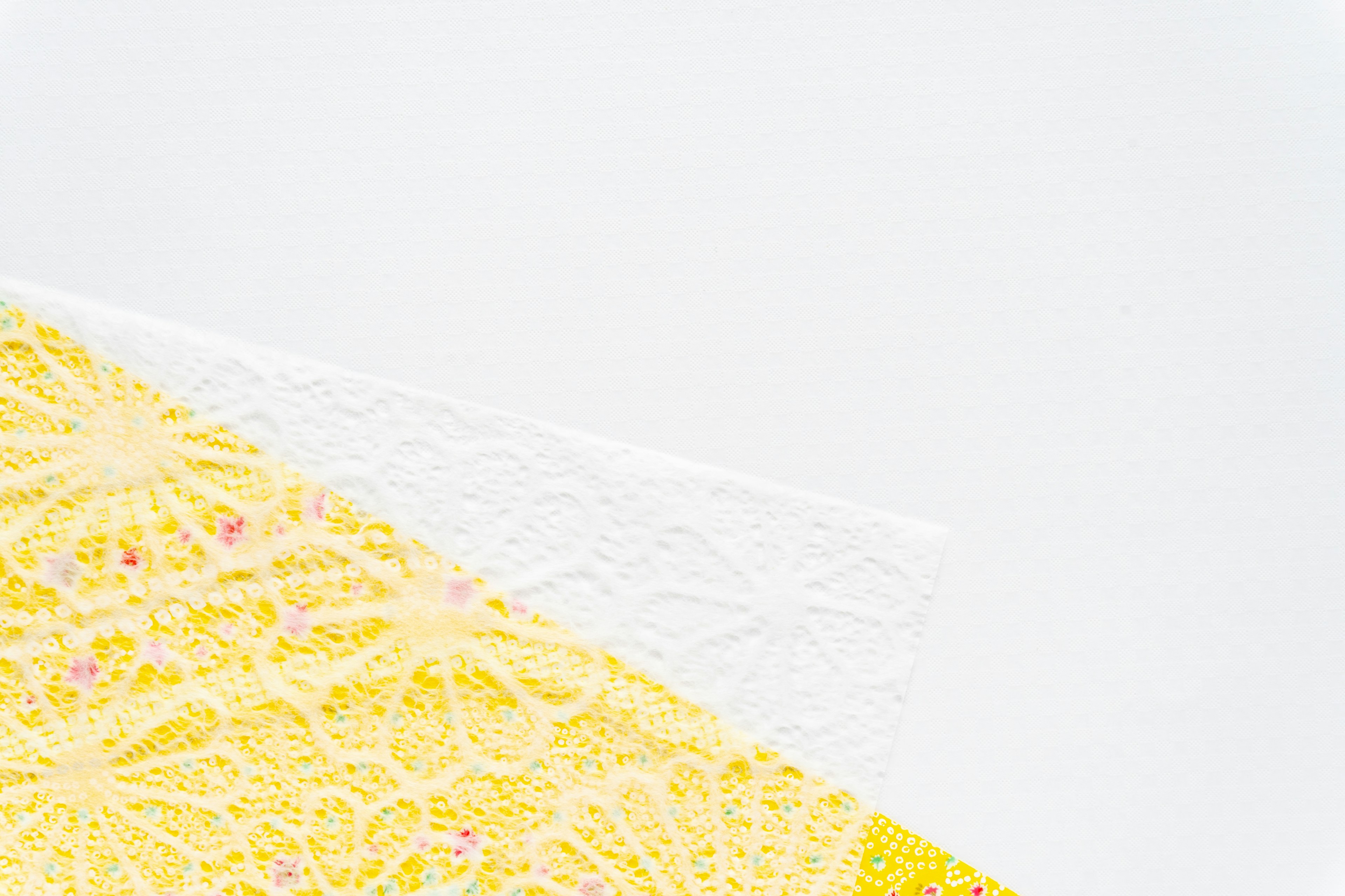 Yellow lace and white lace overlapping on a white background