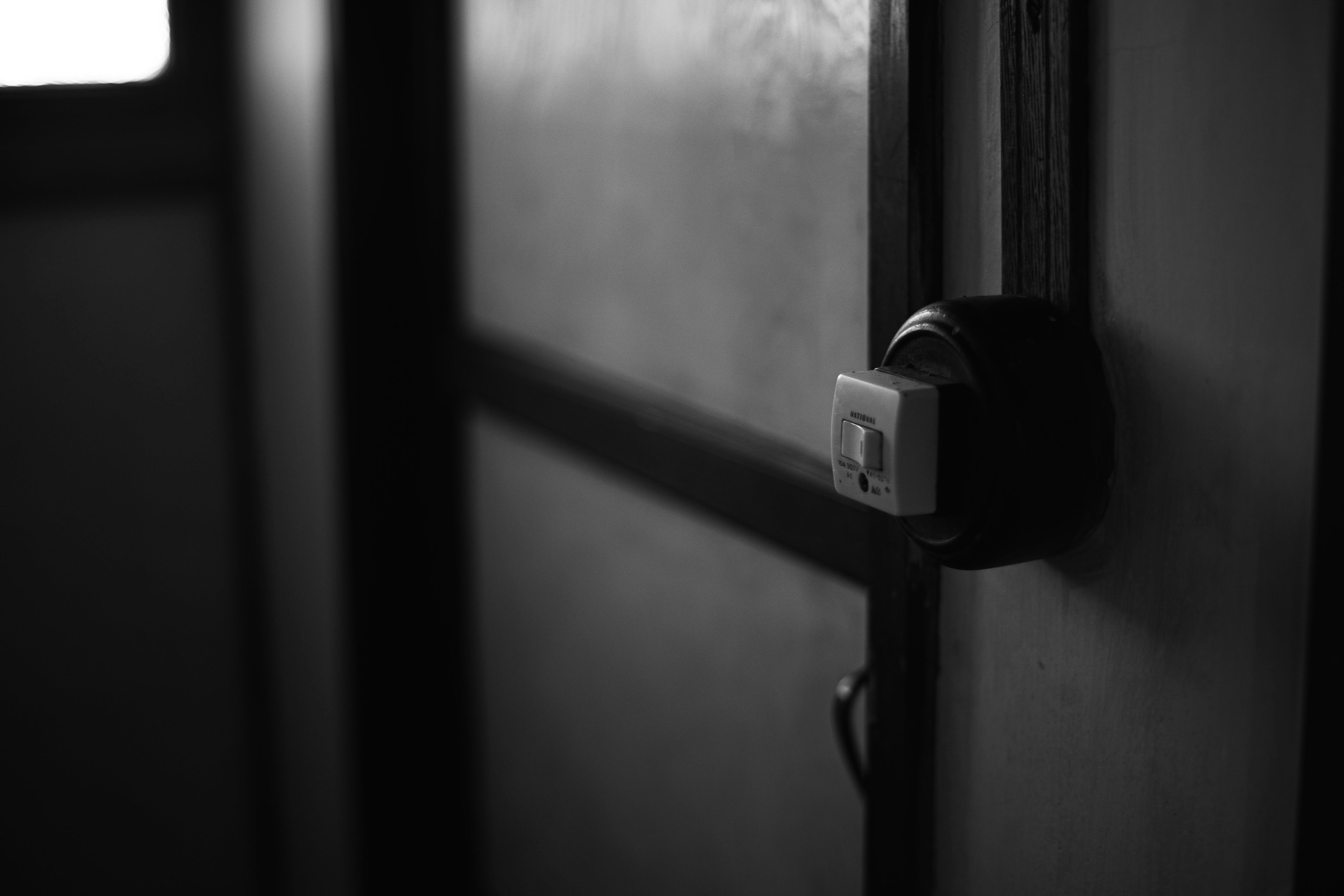 Close-up image of a black and white door featuring a lock and switch