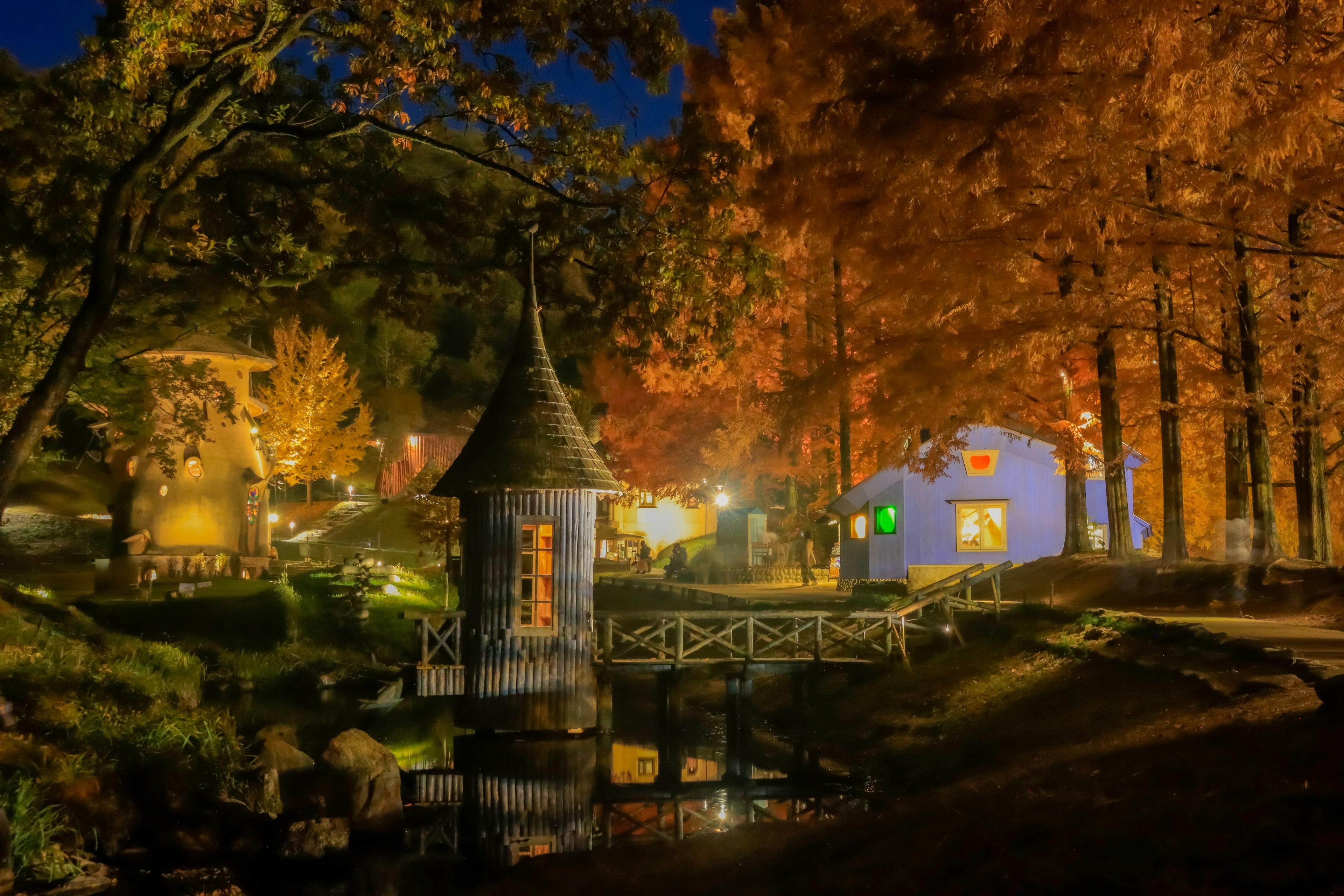 Belle scène nocturne d'automne avec une petite maison à tour et des arbres colorés