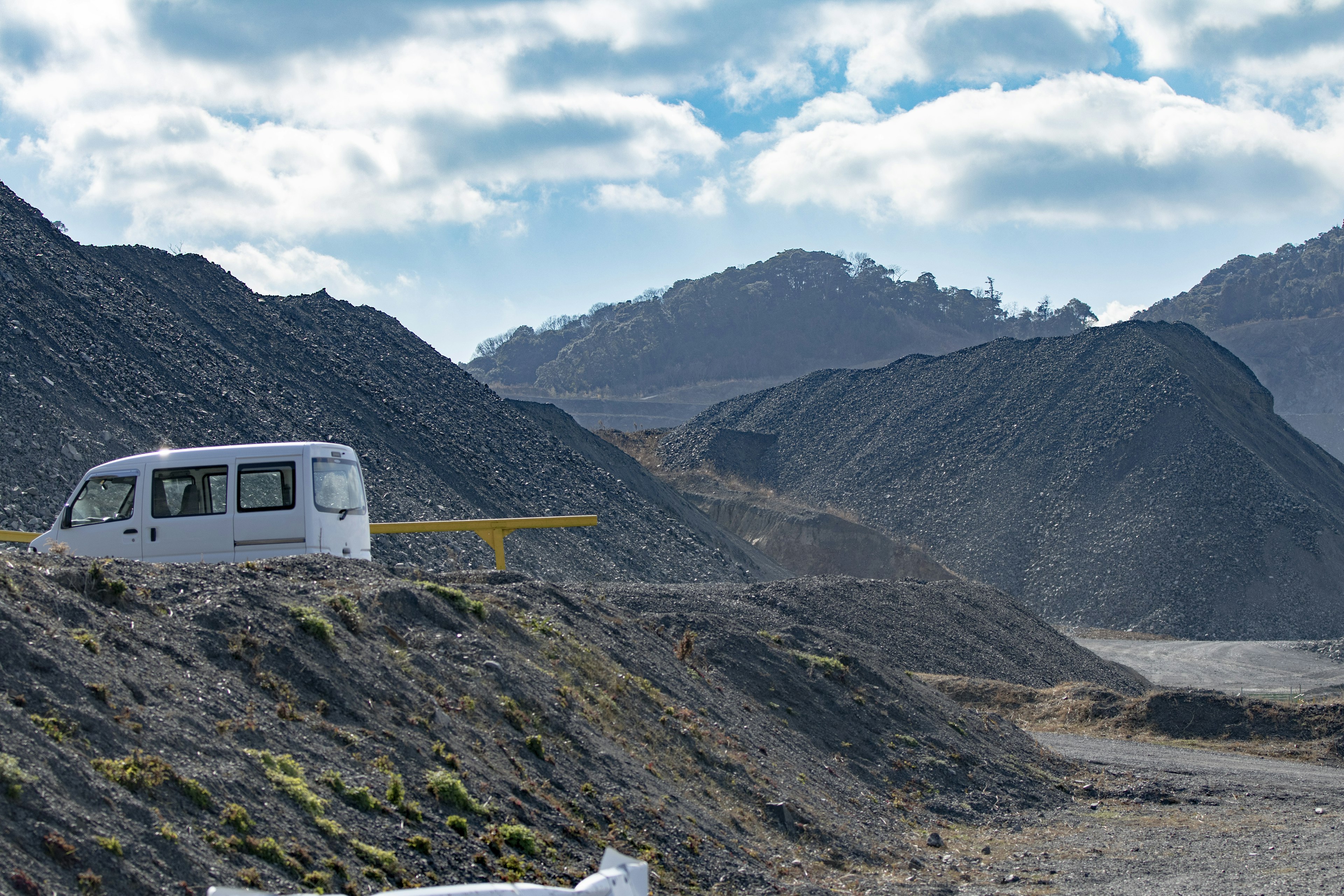 Una furgoneta blanca estacionada entre montañas bajo un cielo azul