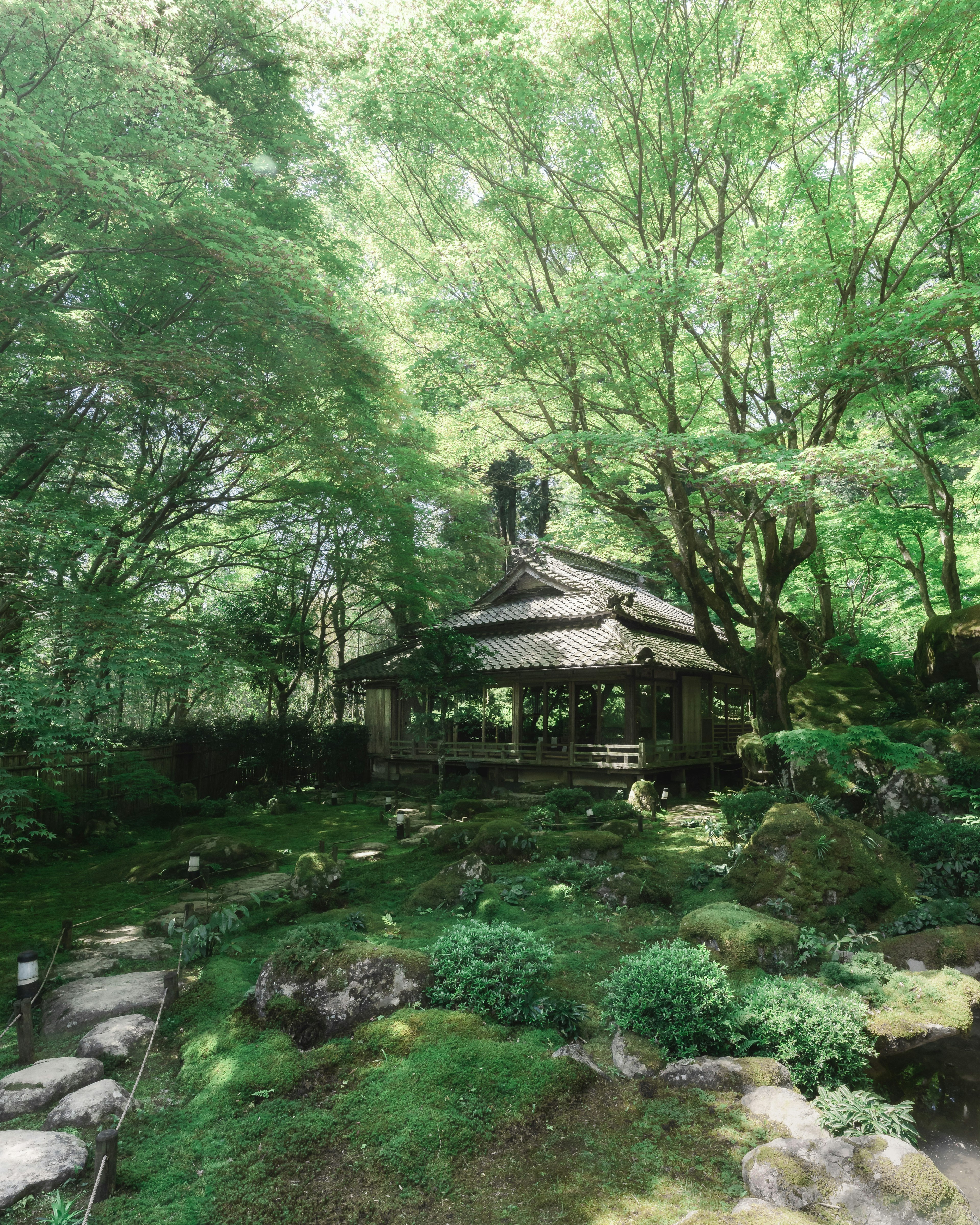 Traditional Japanese hut in a lush green garden