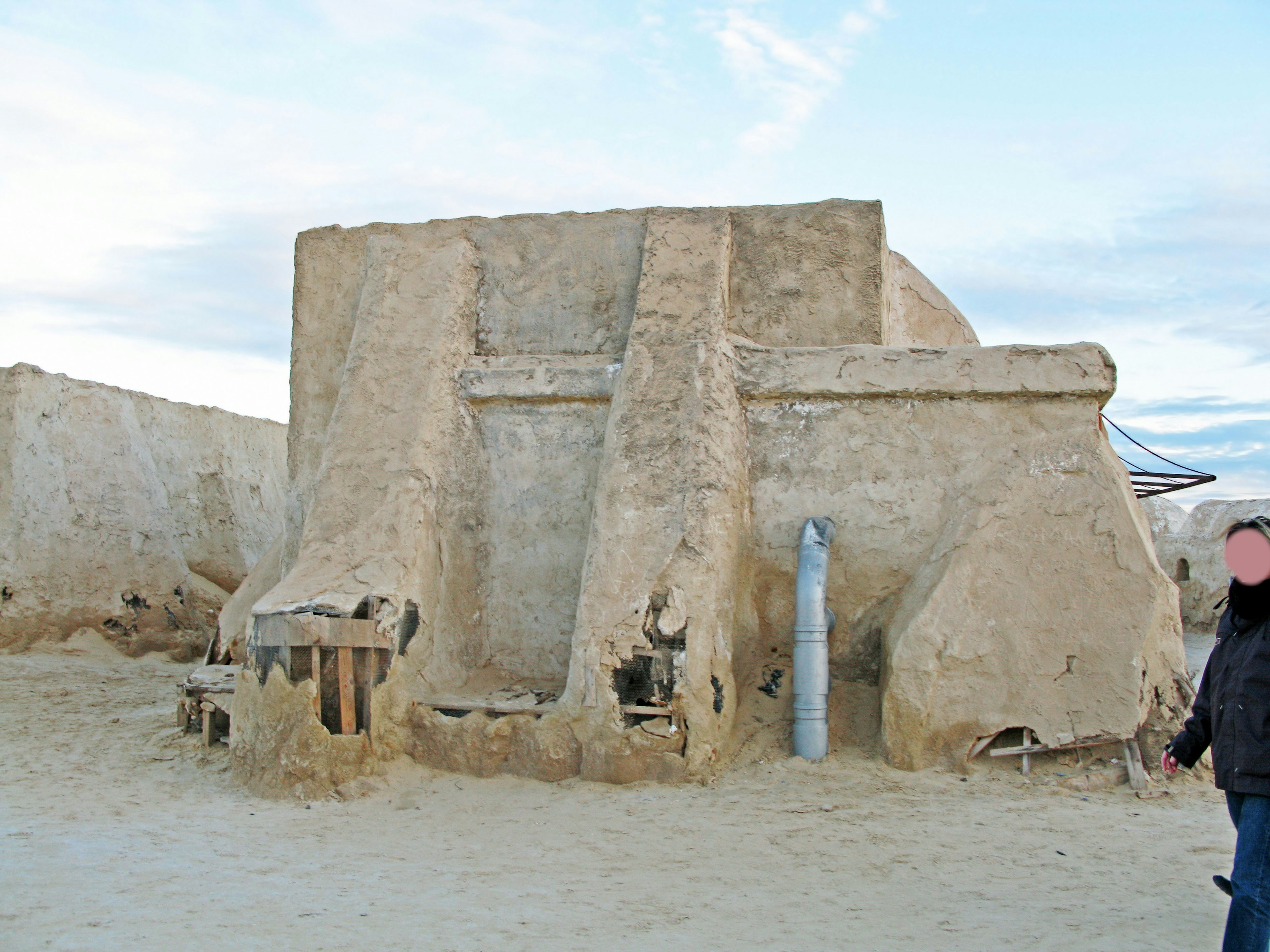 砂漠の中にある土製の建物と人