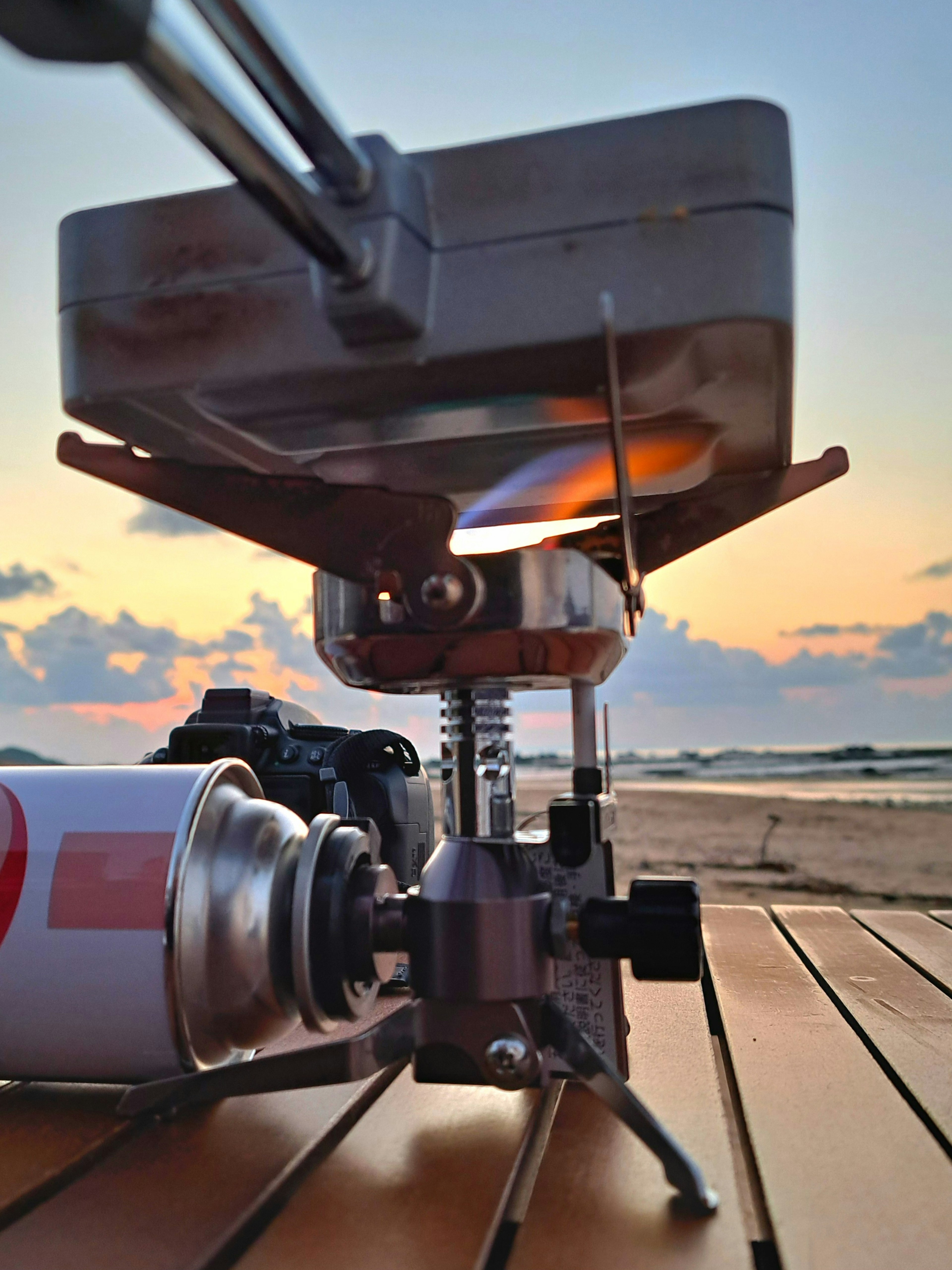 夕焼けのビーチでのカメラとバーナーの写真