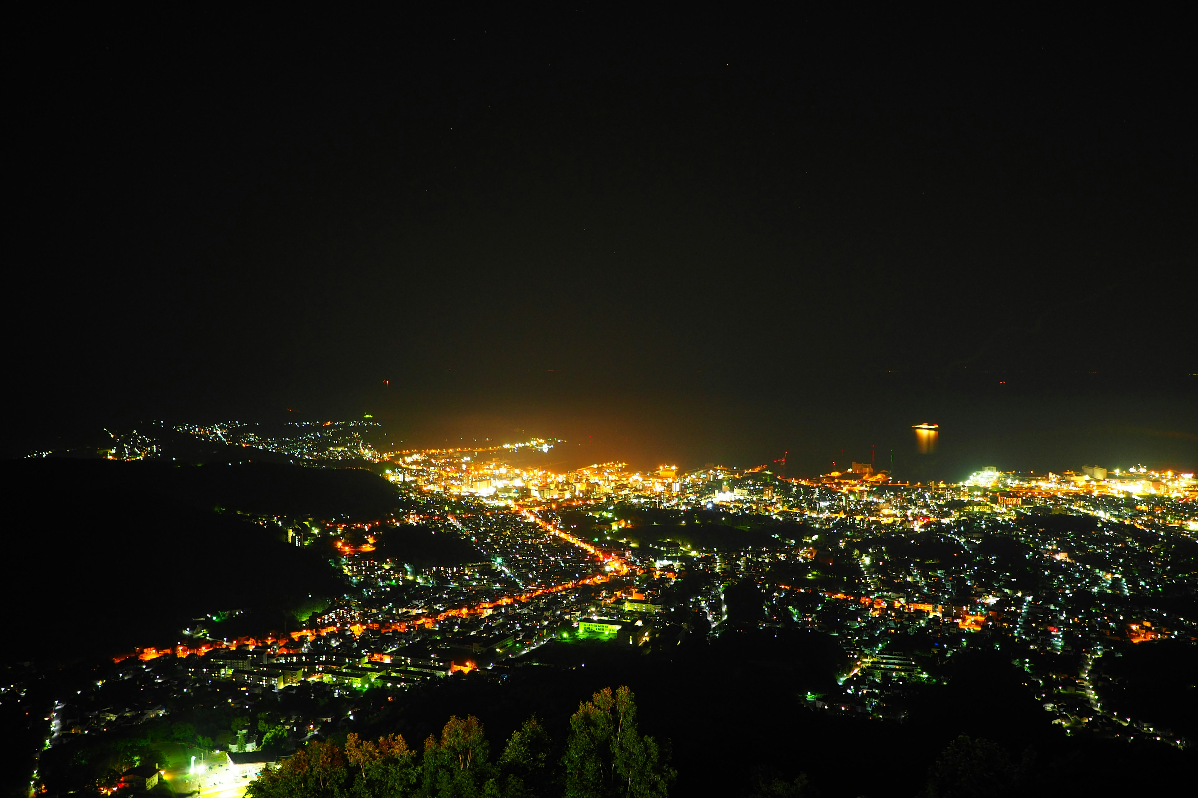 Panoramic view of a city at night with bright streetlights and buildings