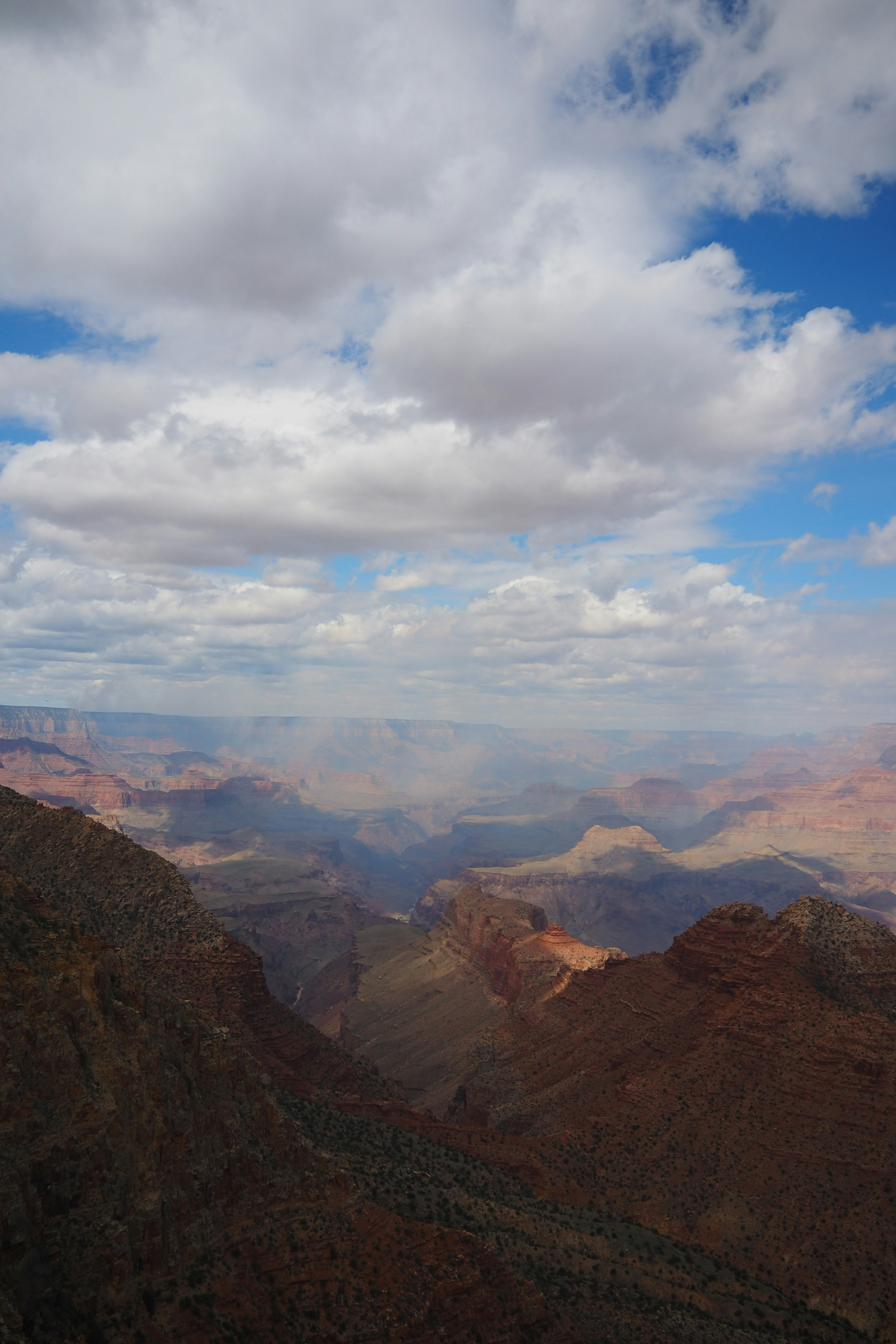 Pemandangan luas Grand Canyon dengan langit biru dan awan