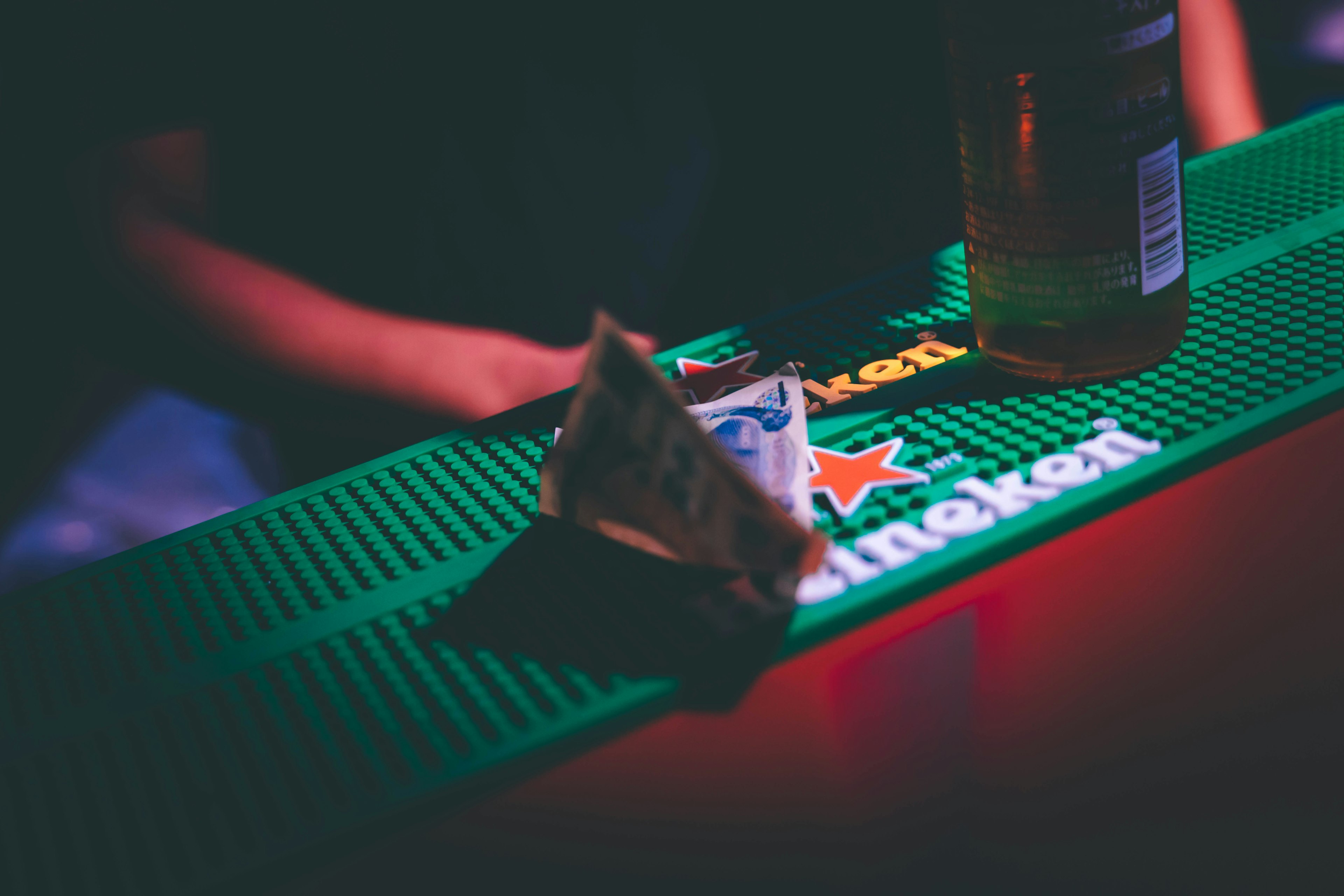 A small snack and a bottle of drink on a bar counter