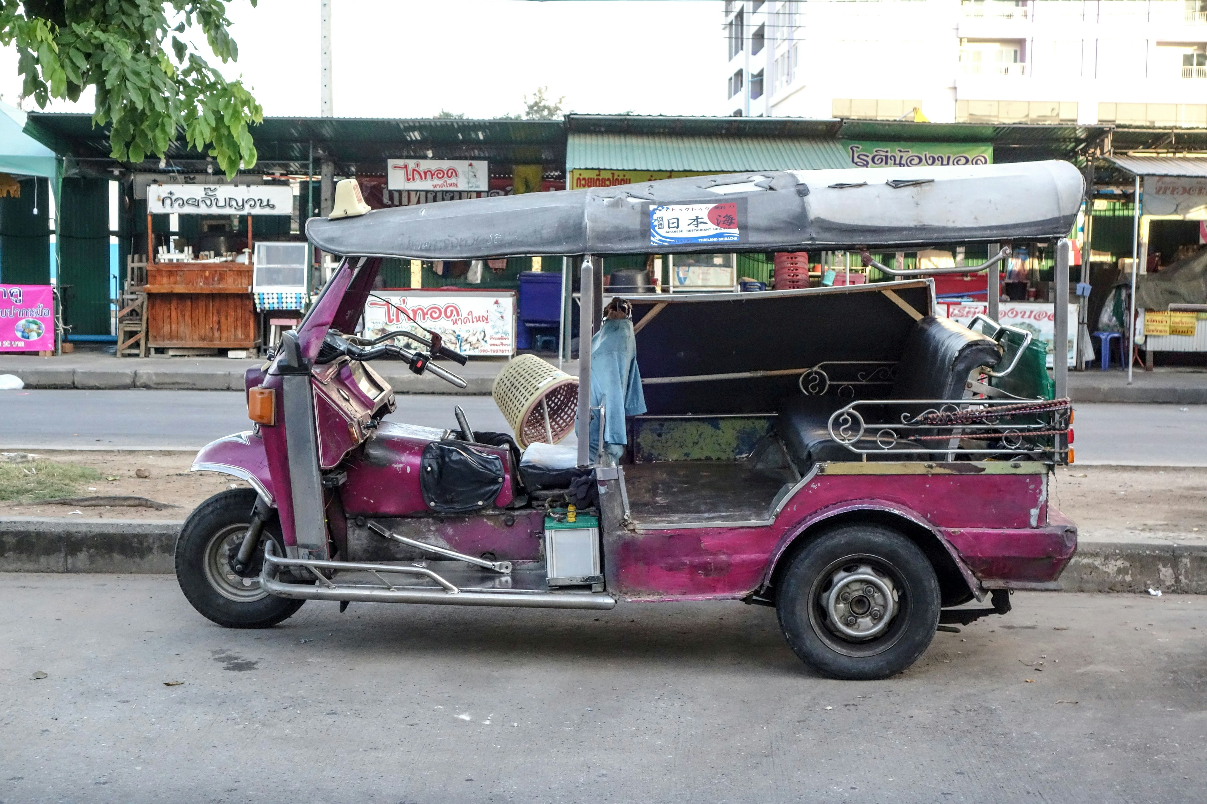 Sebuah tuk-tuk berwarna-warni diparkir di pinggir jalan