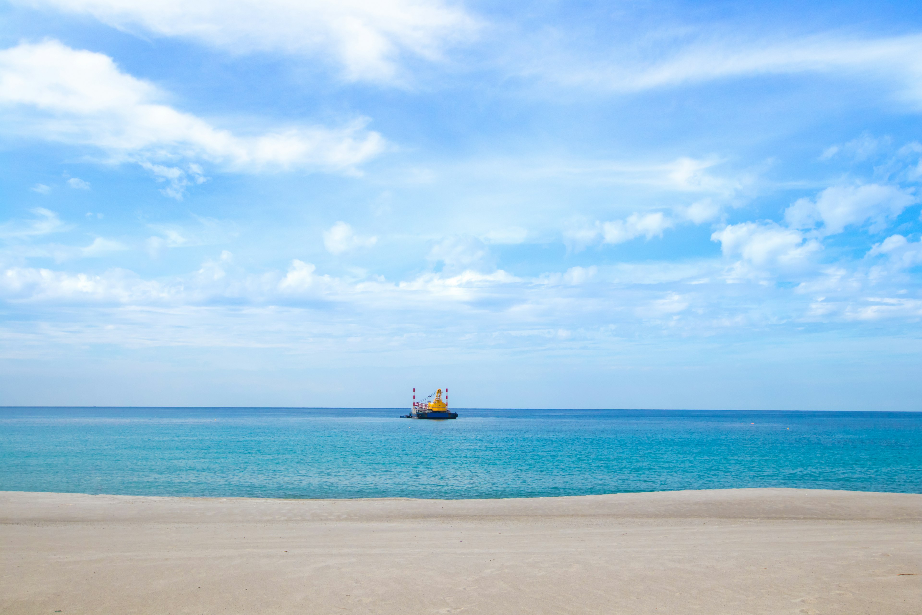 Pantai indah dengan kapal di laut biru di bawah langit cerah