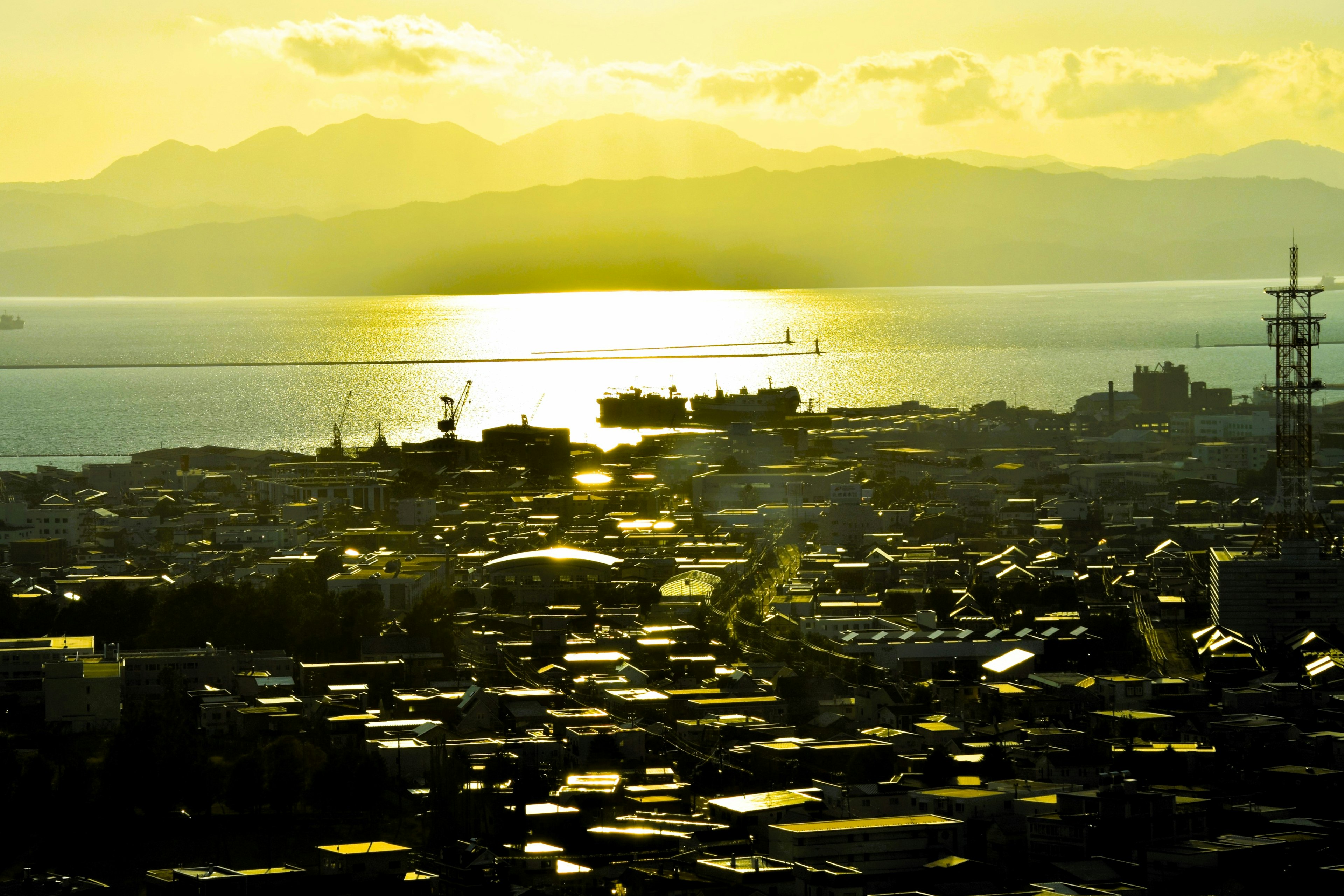 Vue panoramique d'une ville avec le coucher de soleil se reflétant sur la mer