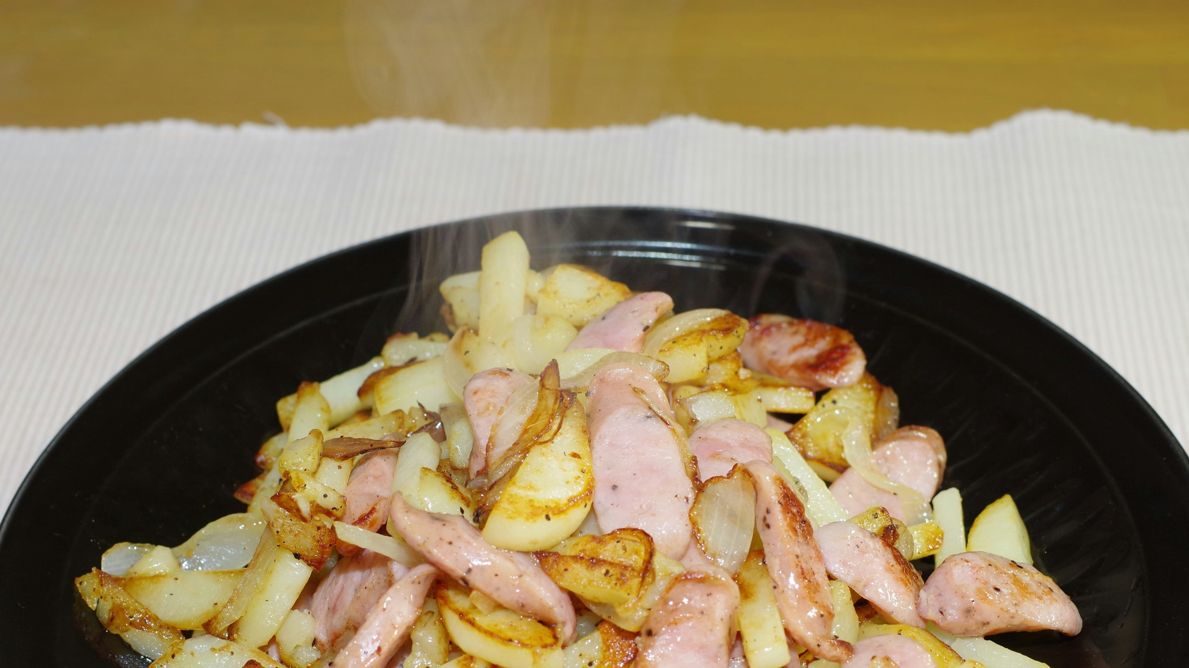 Steaming plate of ham and fried potatoes