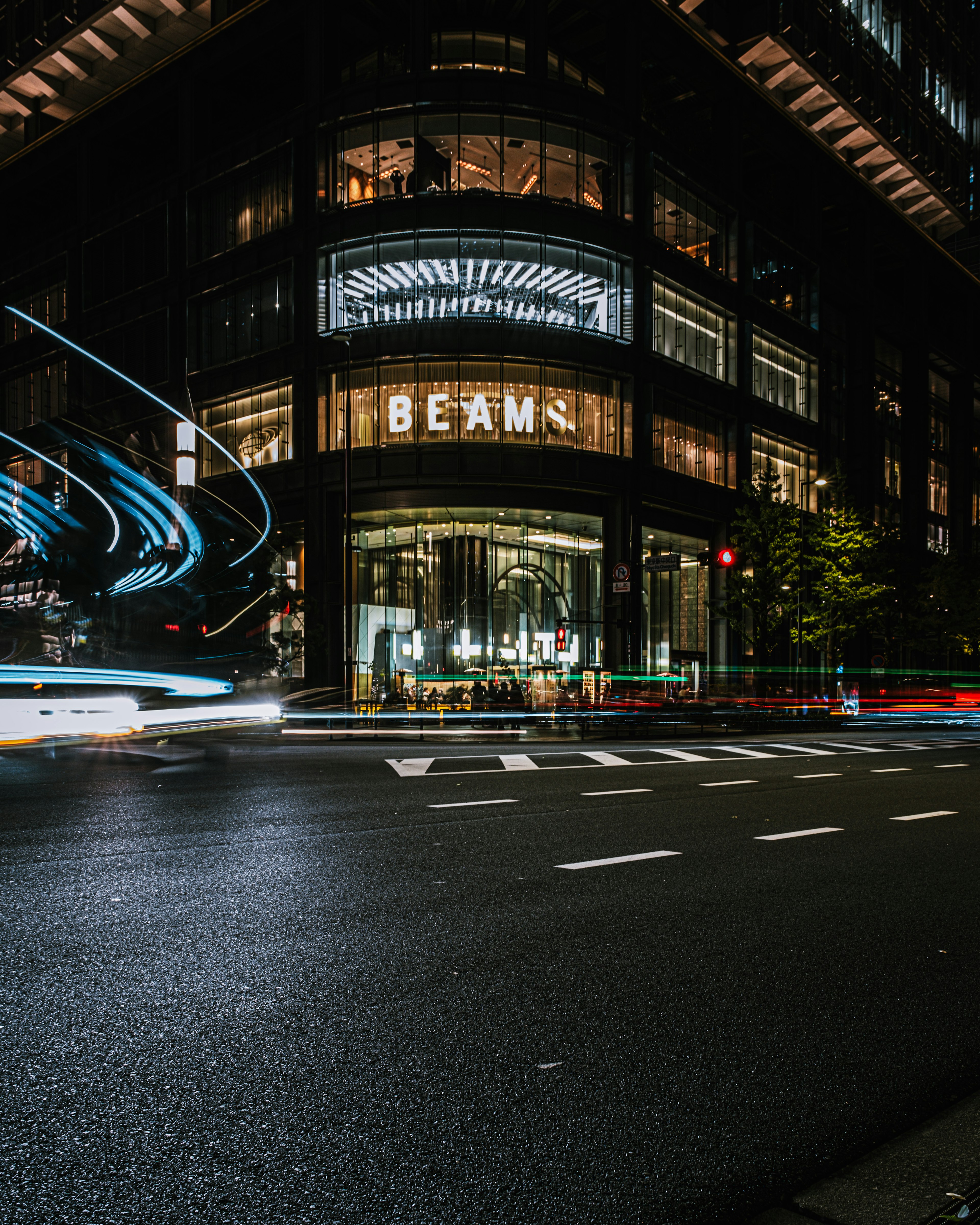 Paysage urbain nocturne avec le bâtiment BEAM et des lumières de voitures en mouvement