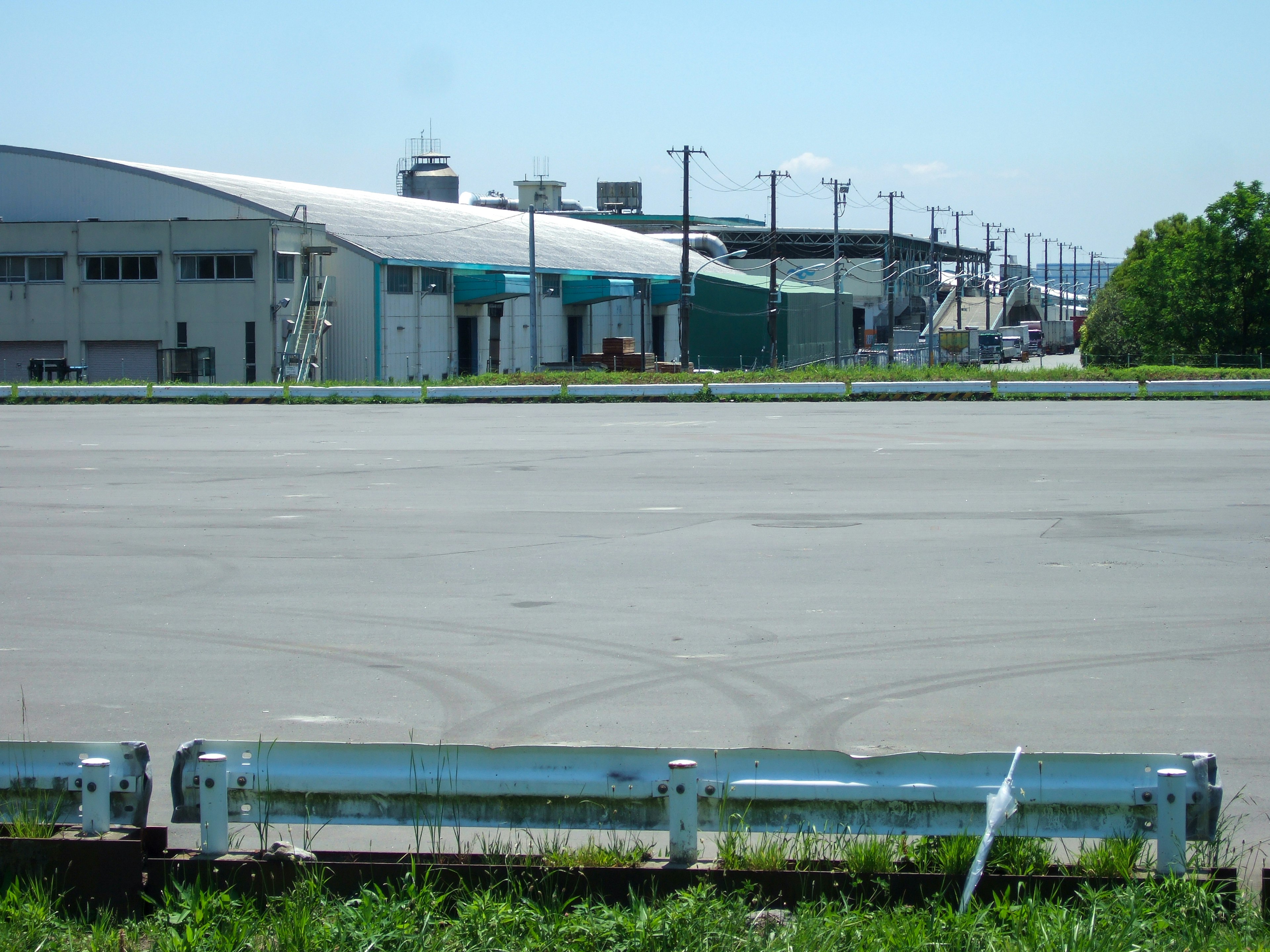 Large paved area with metal guardrail in an industrial setting