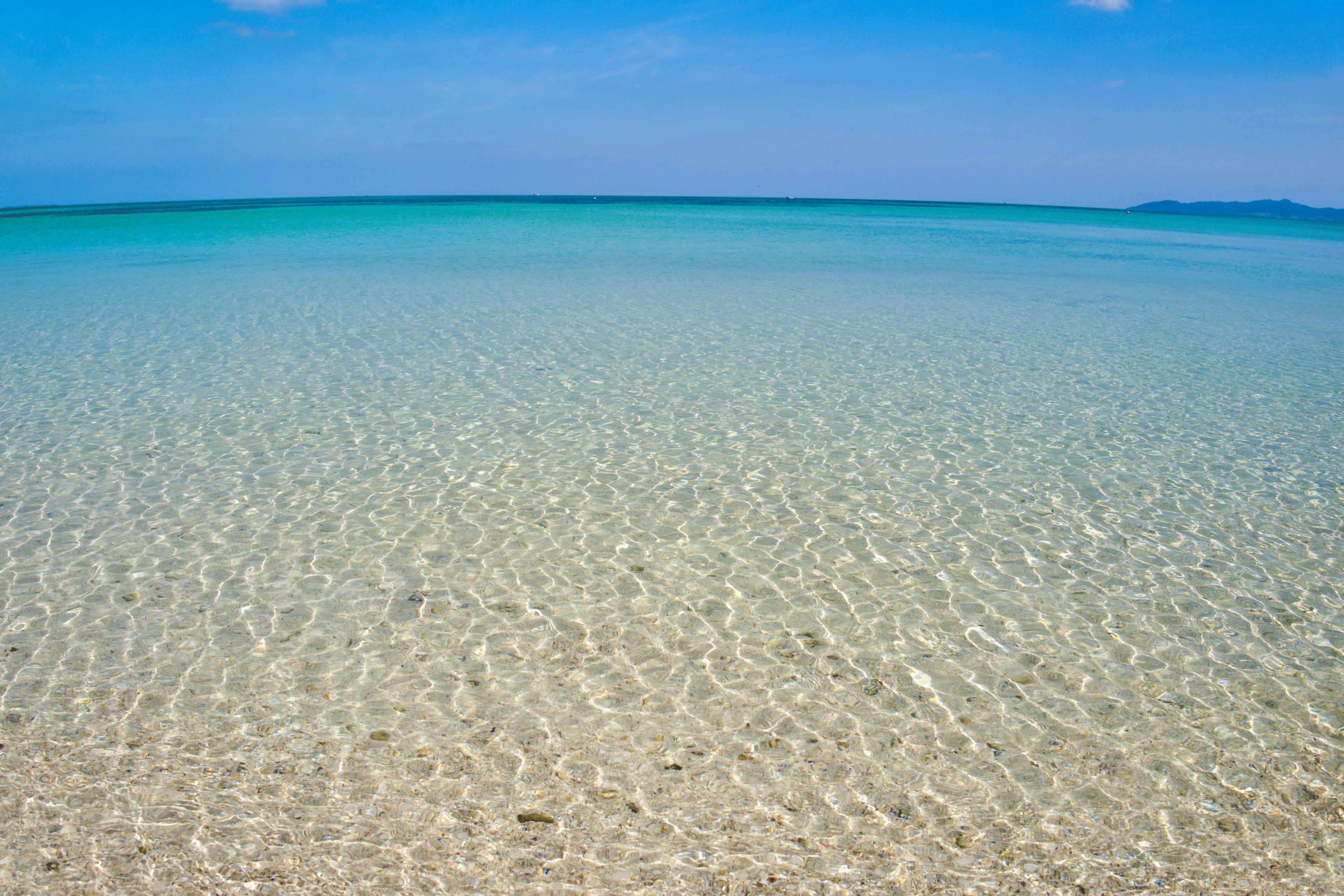 Acqua turchese trasparente con leggere increspature sotto un cielo azzurro