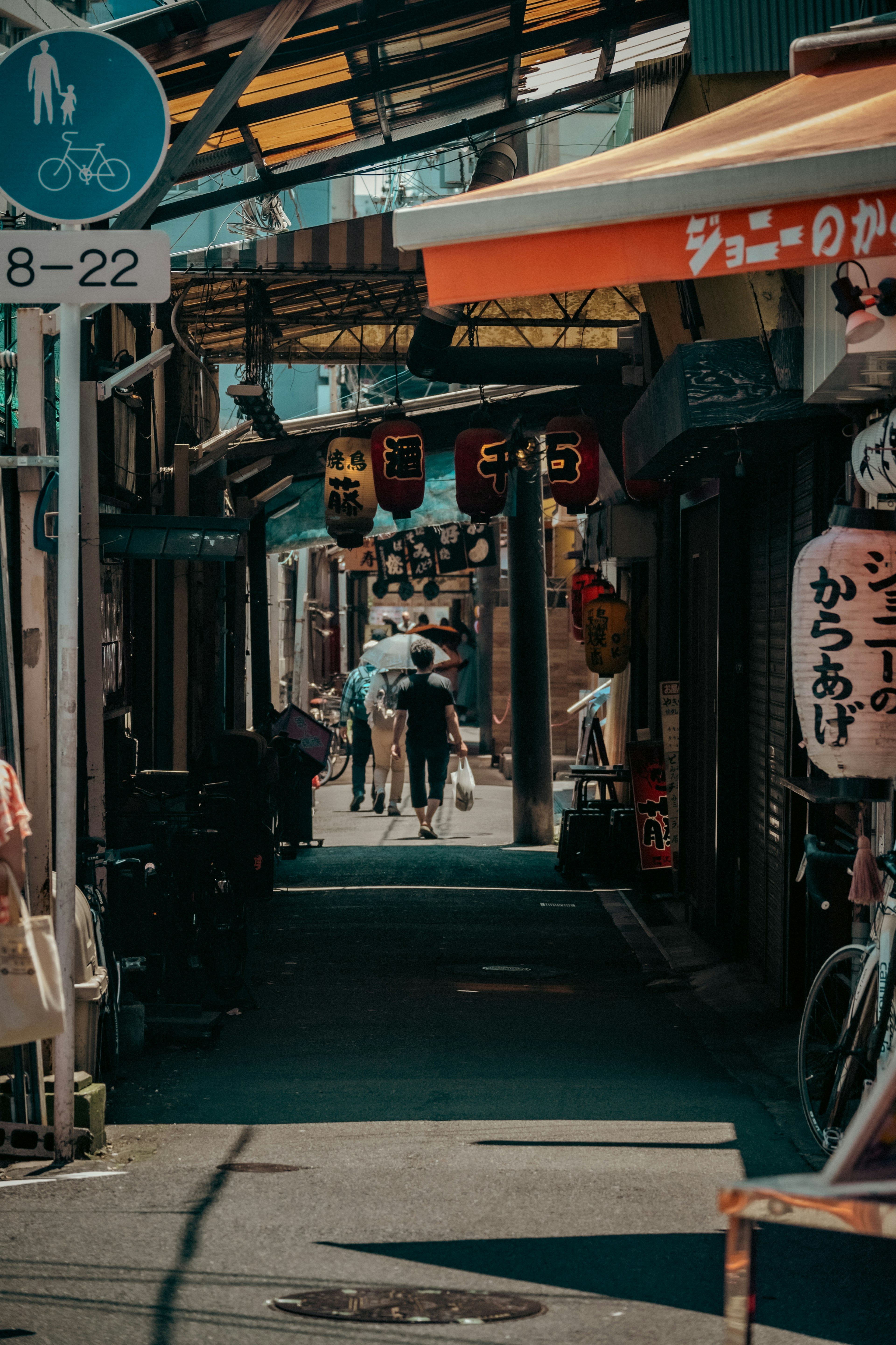 Callejón japonés estrecho con personas caminando