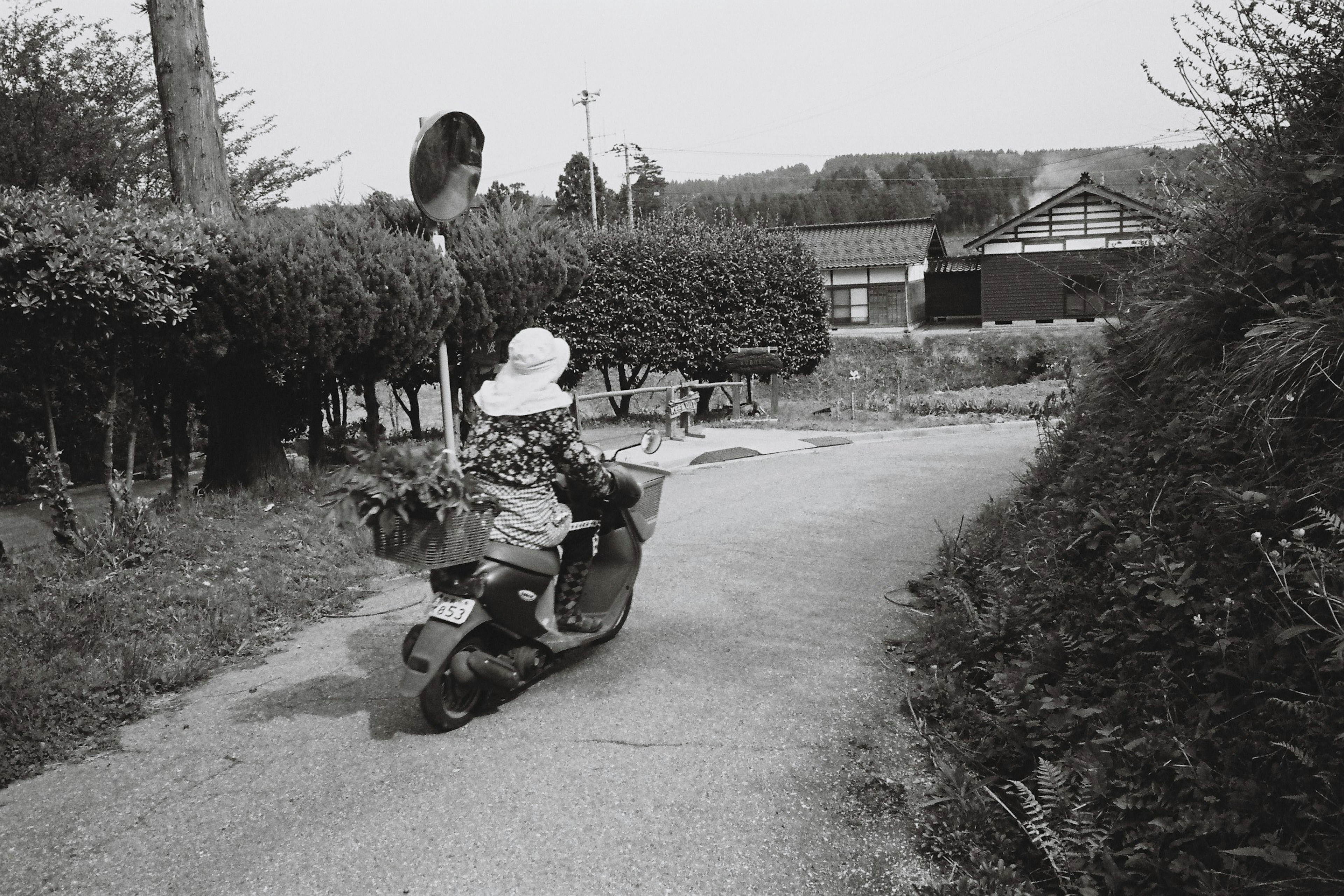 Schwarzweißfoto eines Kindes, das auf einem kleinen Fahrrad auf einem gewundenen Weg fährt