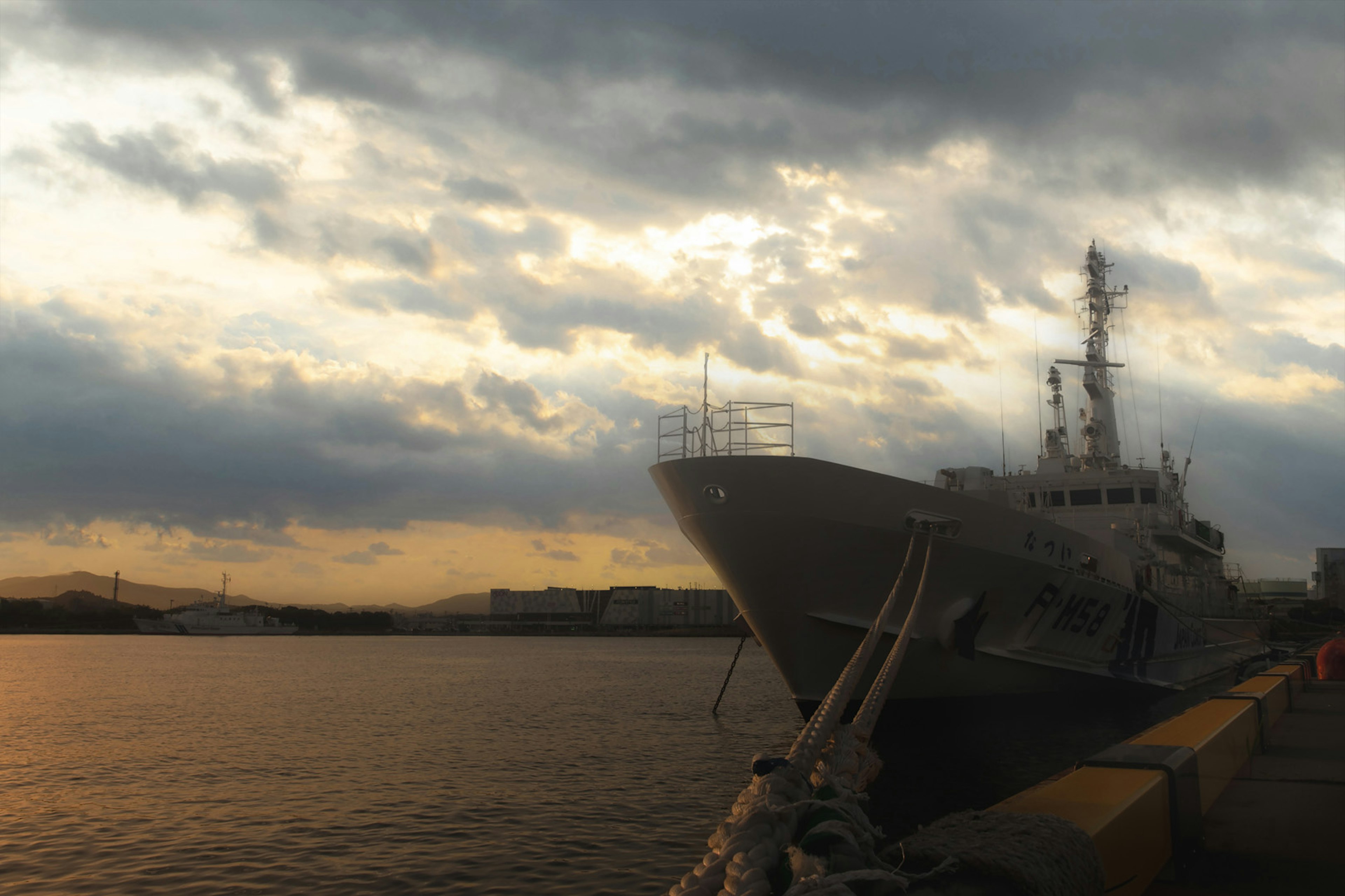 Schiff im Hafen während des Sonnenuntergangs mit bewölktem Himmel