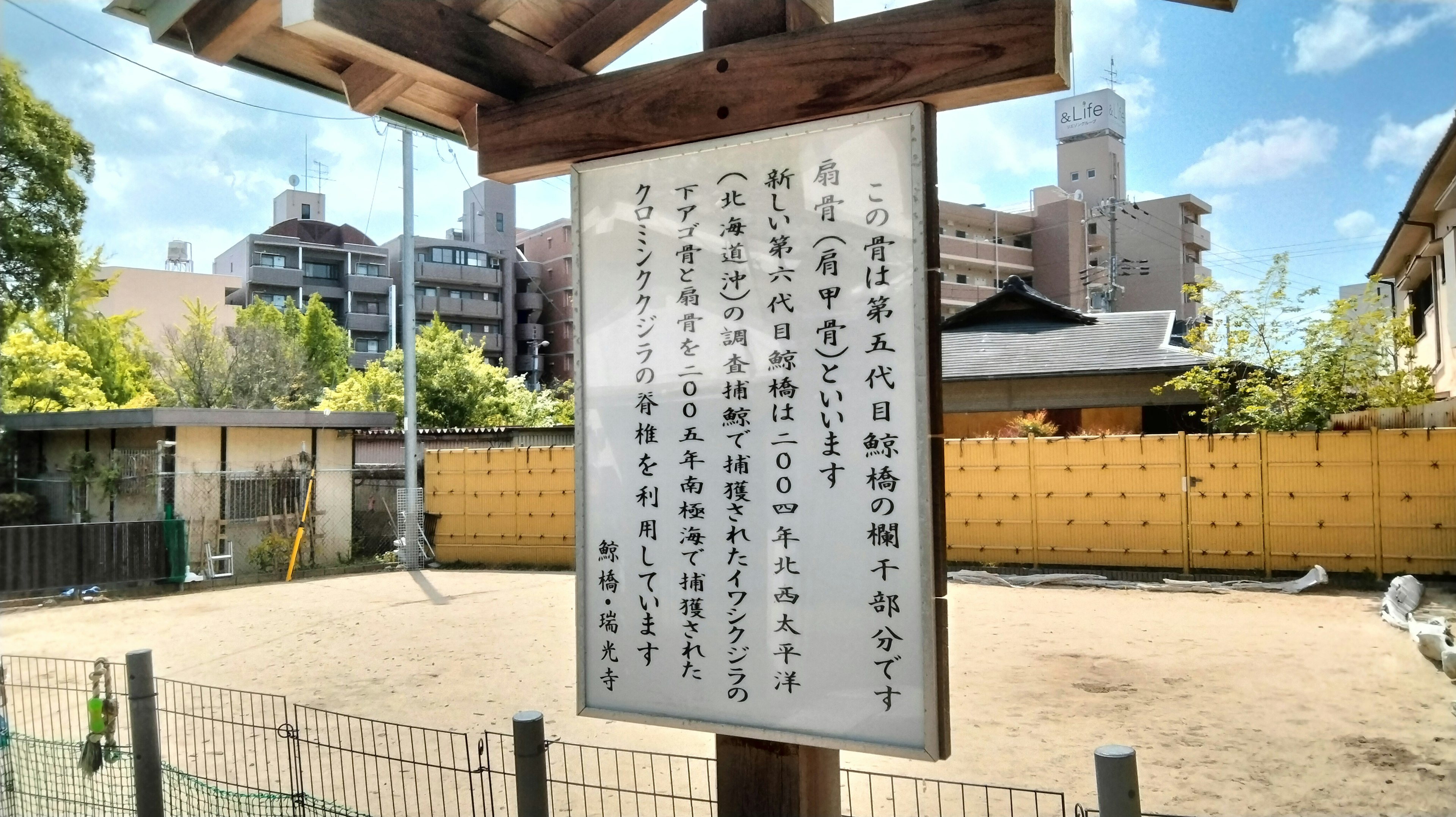 公園の看板と周囲の建物と青空