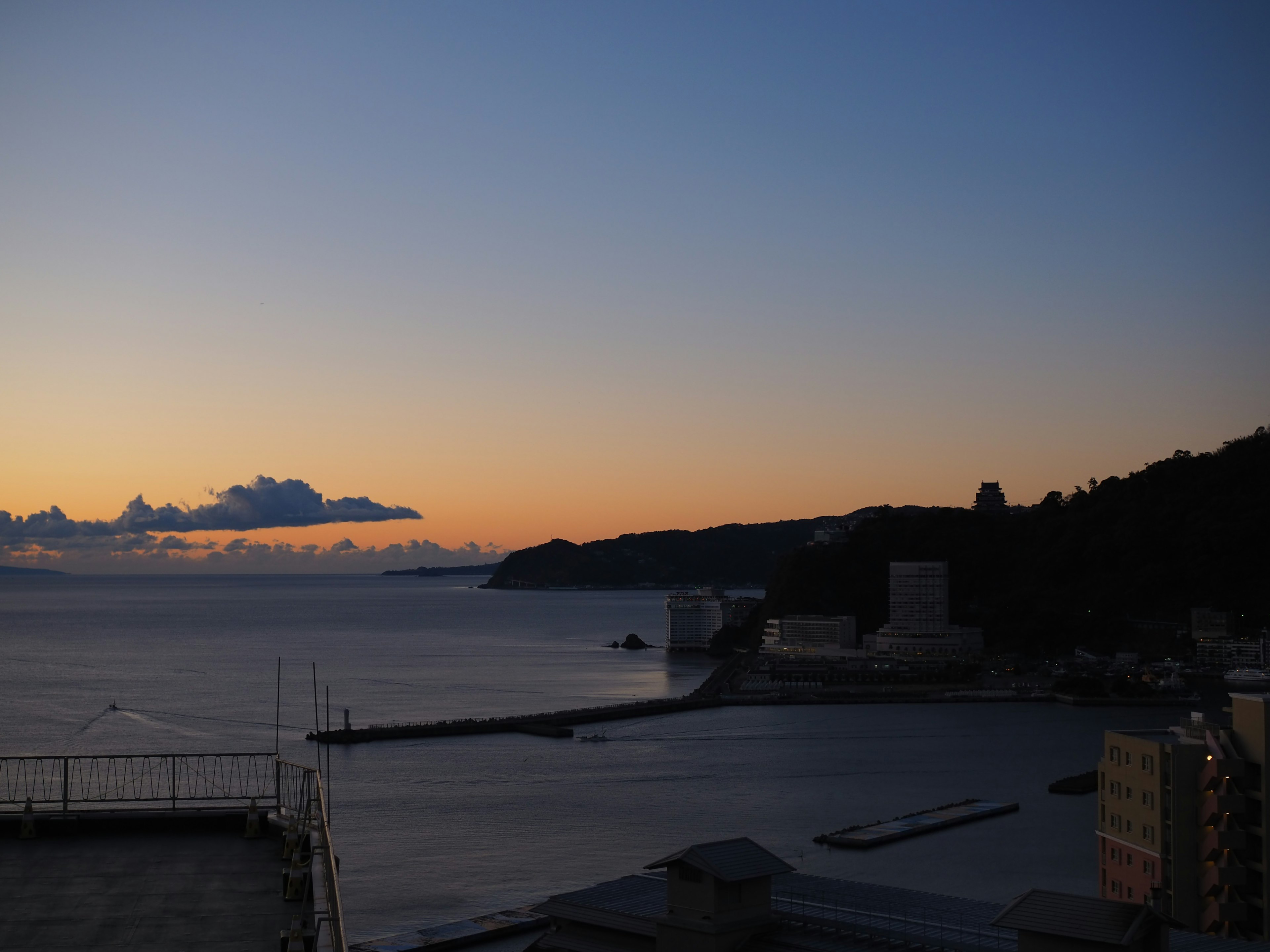 Tramonto sull'oceano con montagne in lontananza