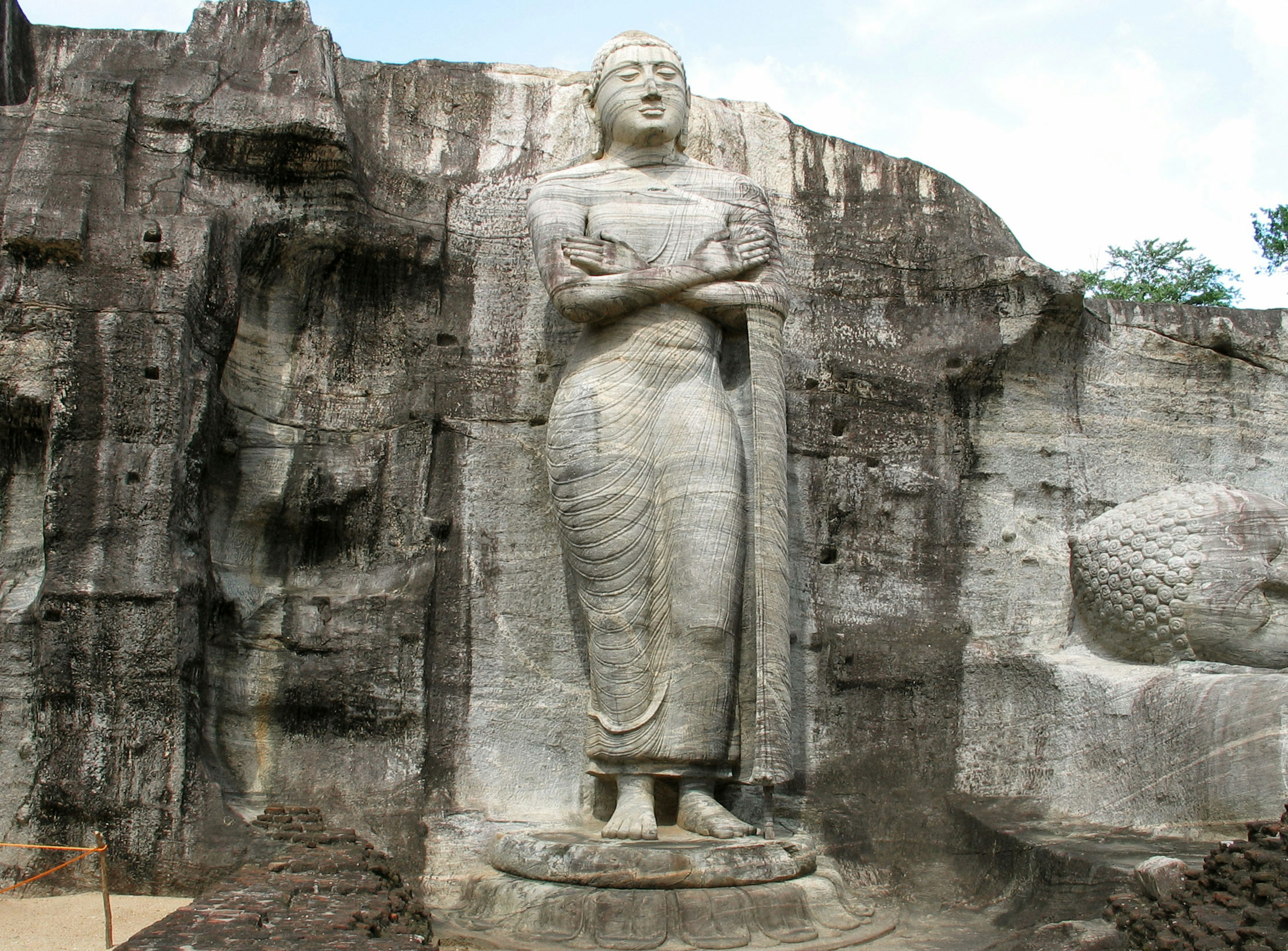 Una grande statua di Buddha scolpita in una parete di roccia