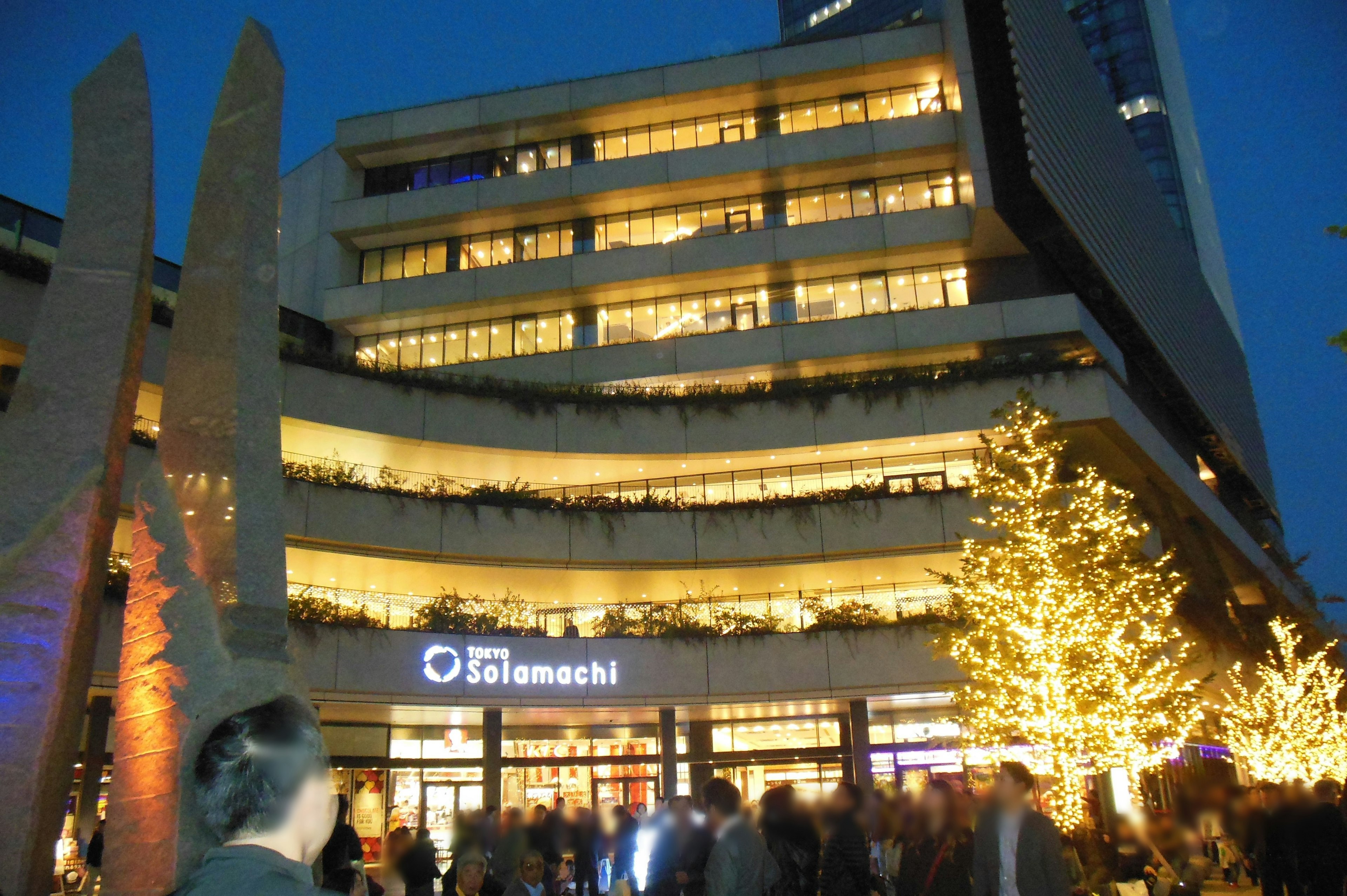 Bright building in nighttime with decorated trees