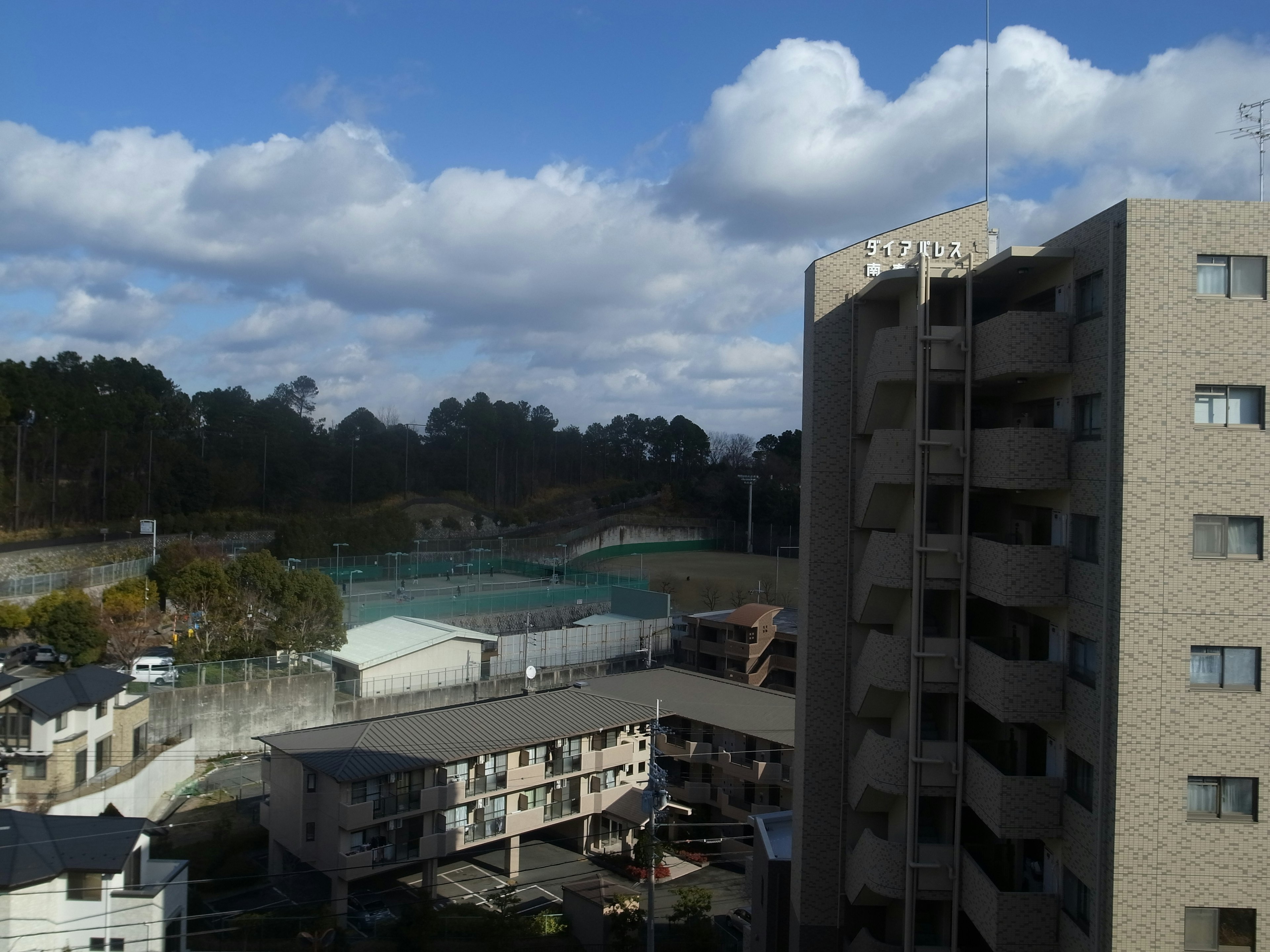 城市風景，有高樓大廈和住宅區 藍天下的白雲 遠處的綠色區域