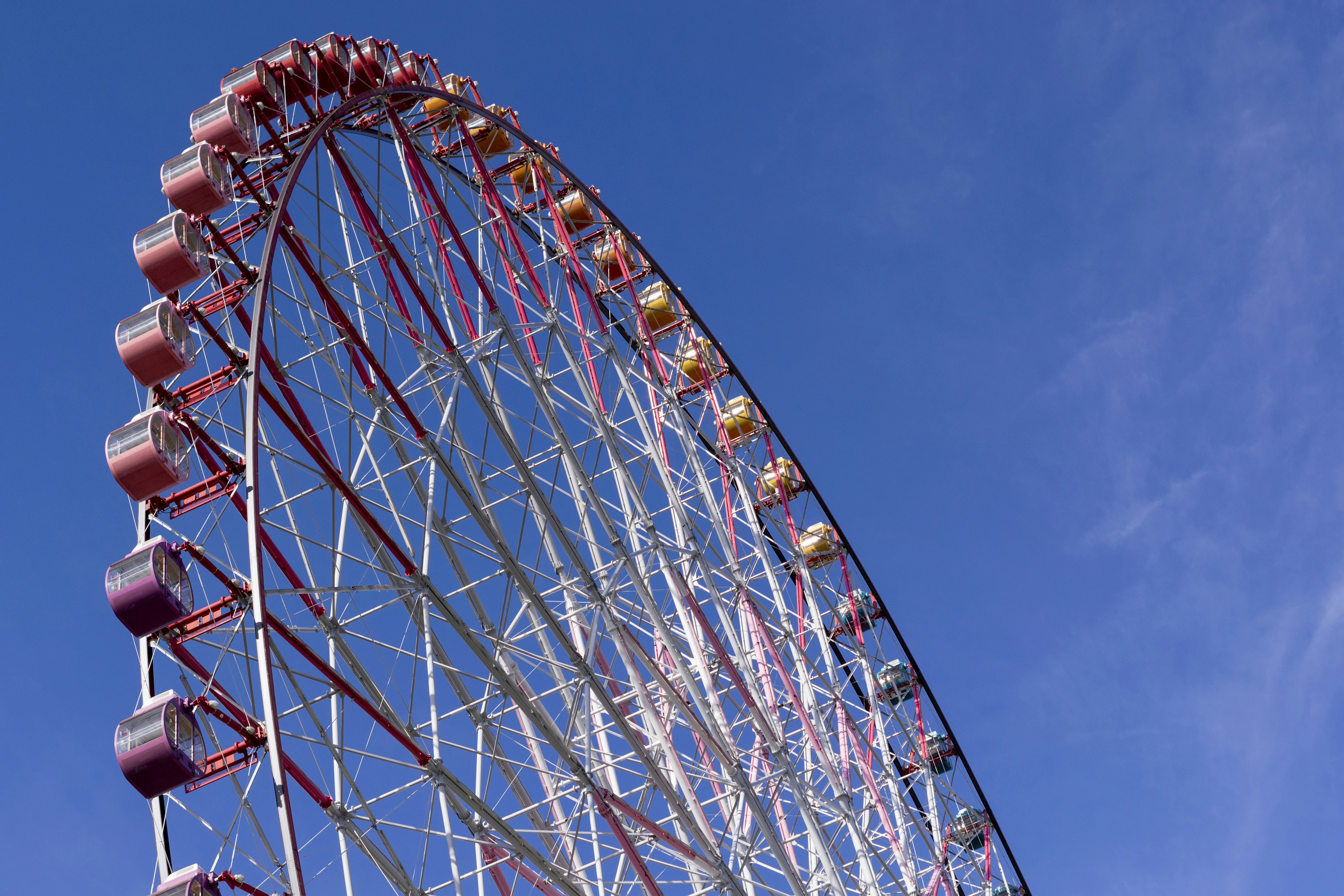 Close-up of a Ferris wheel against a blue sky