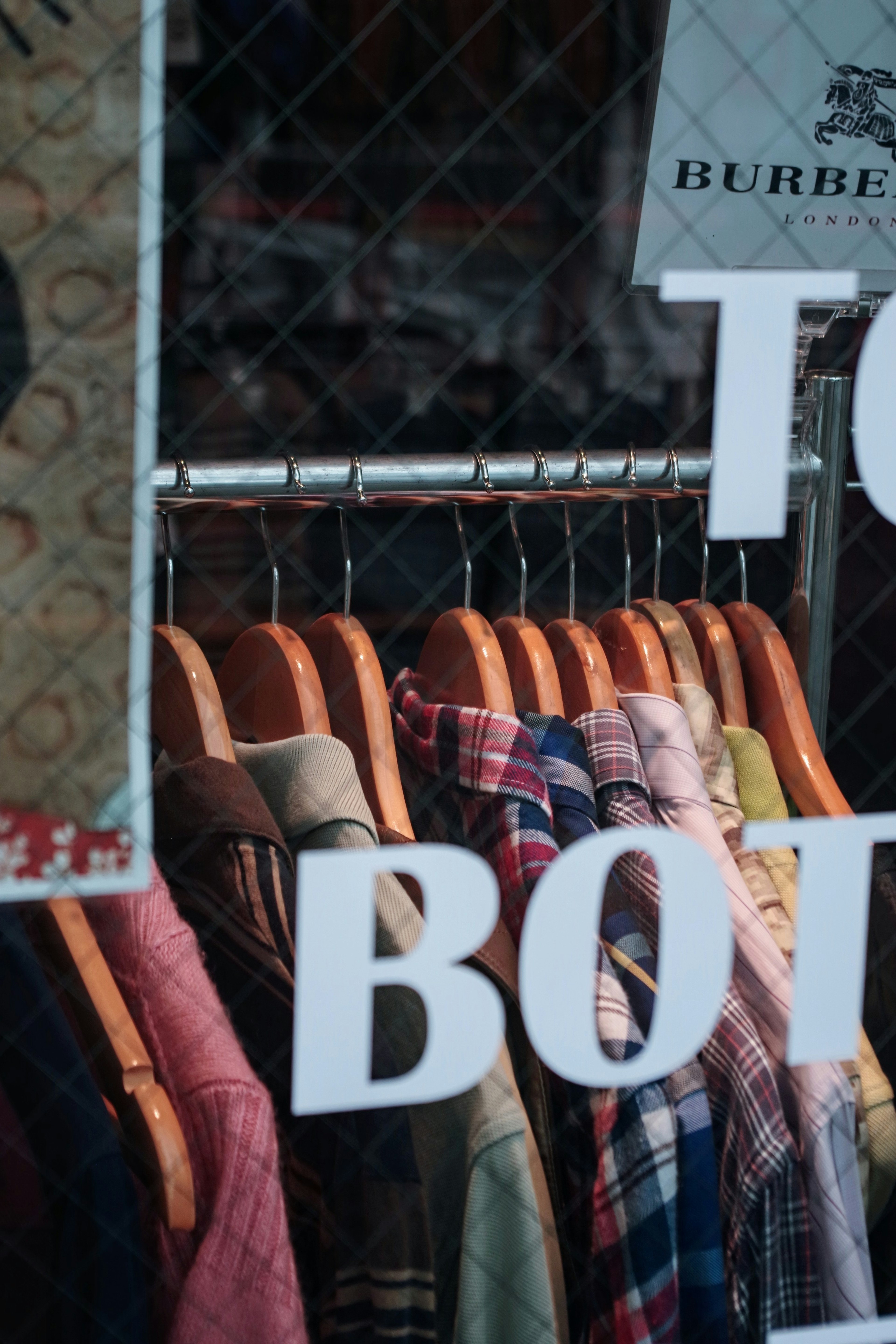 Colección colorida de camisas colgadas en una vitrina con la palabra "BOTT"