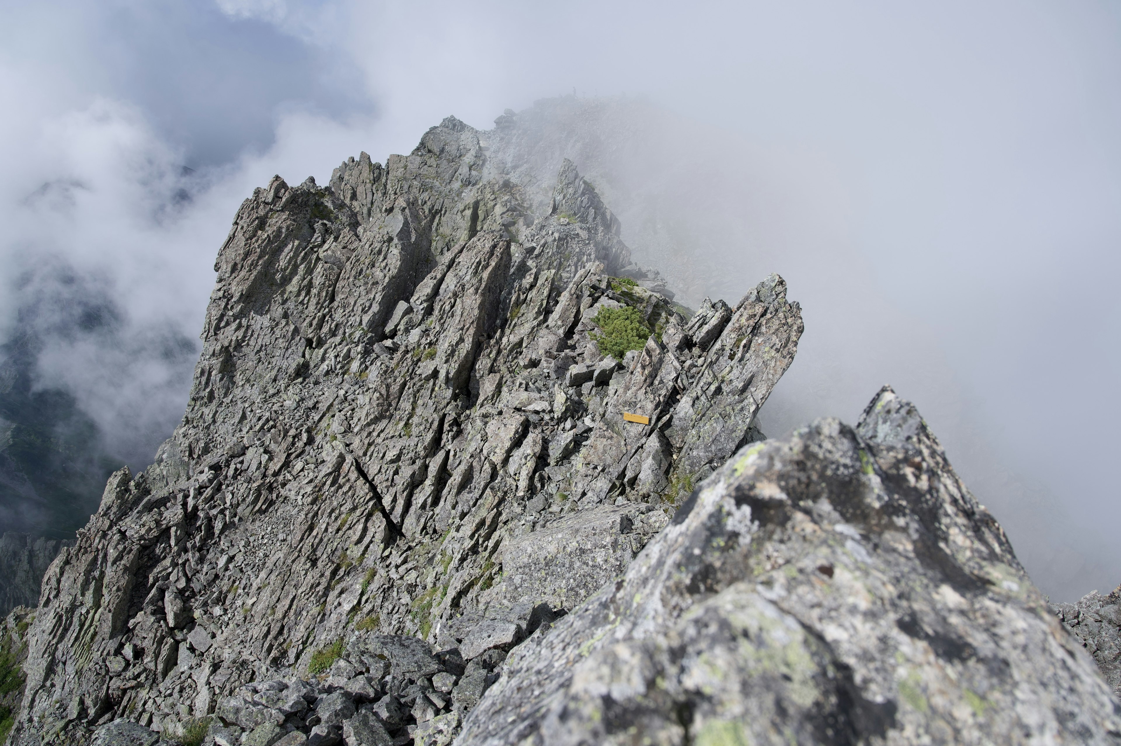 Pico rocoso afilado envuelto en niebla con textura áspera