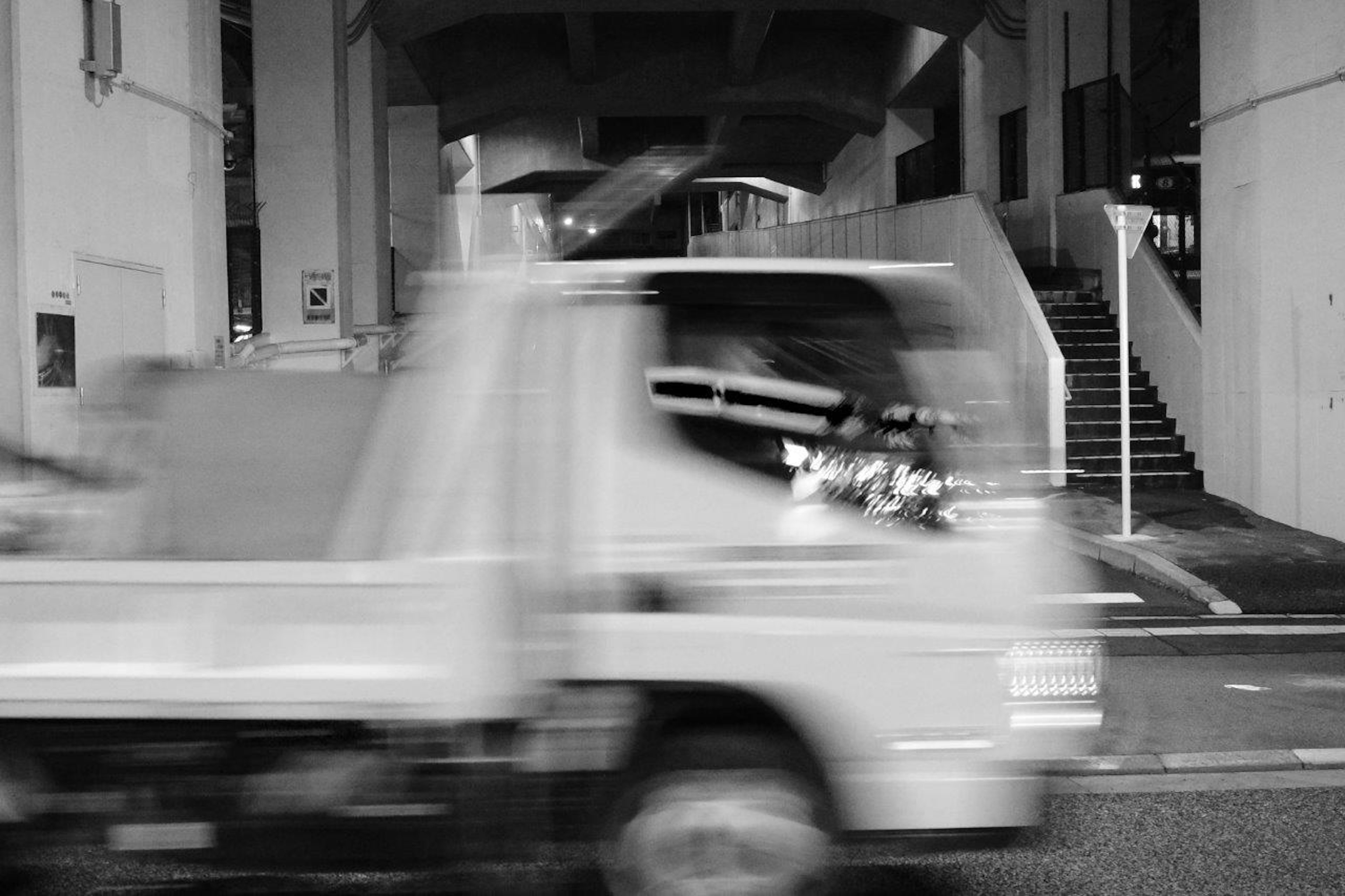 黑白中模糊的卡車經過城市街道的視圖