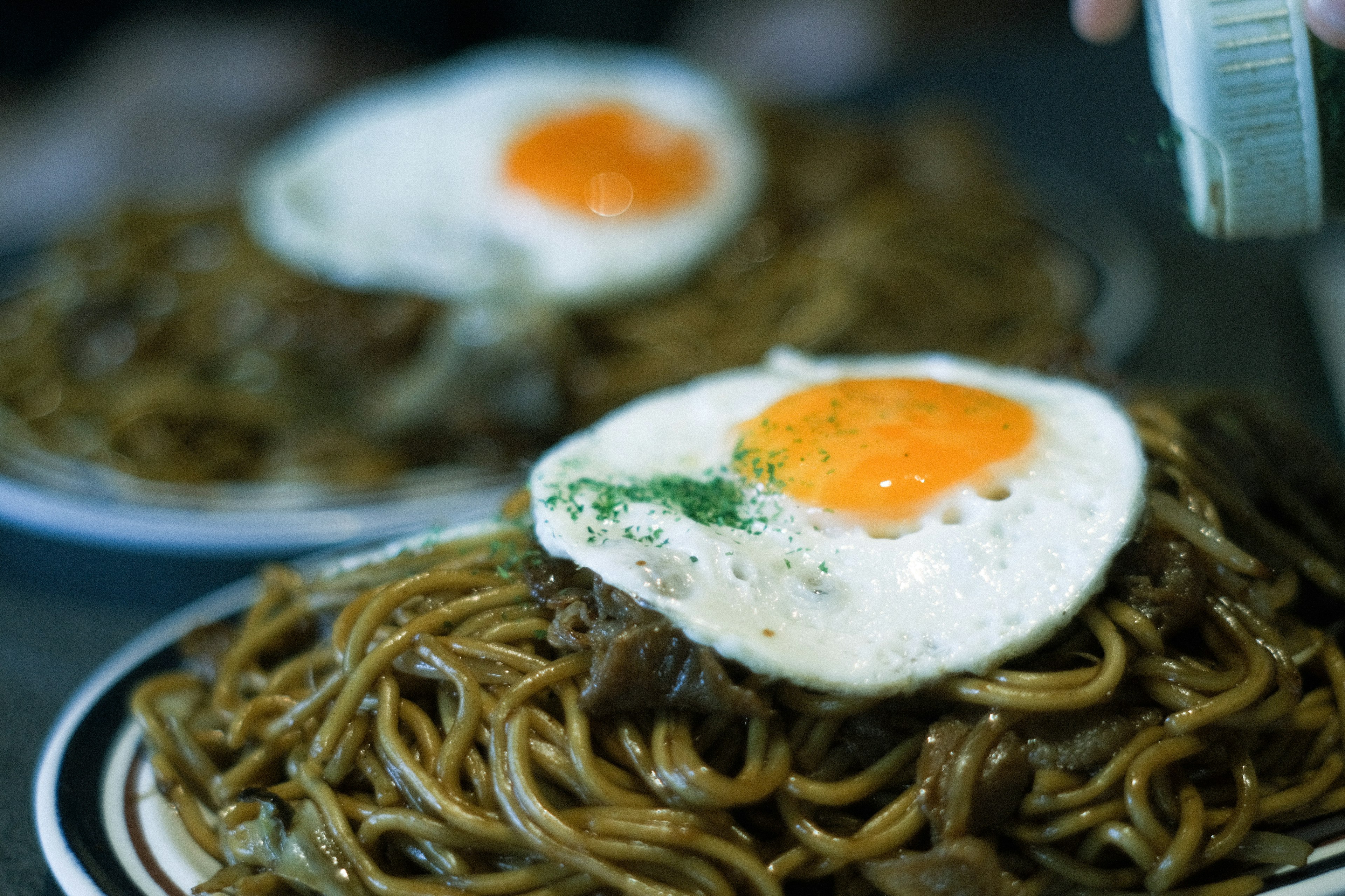 Noodles saltati guarniti con uova al tegamino