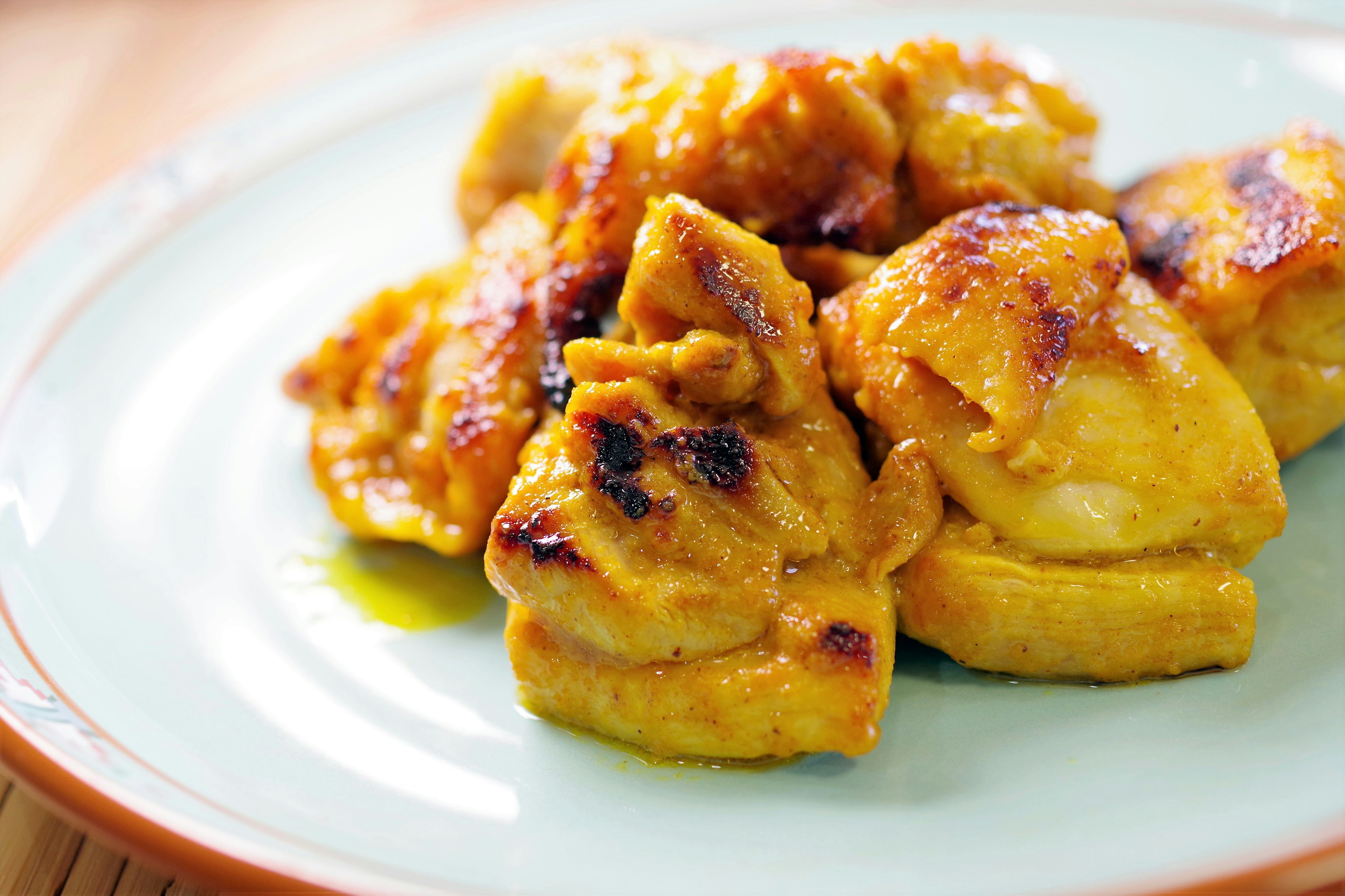 Plate of grilled chicken pieces with a golden brown color