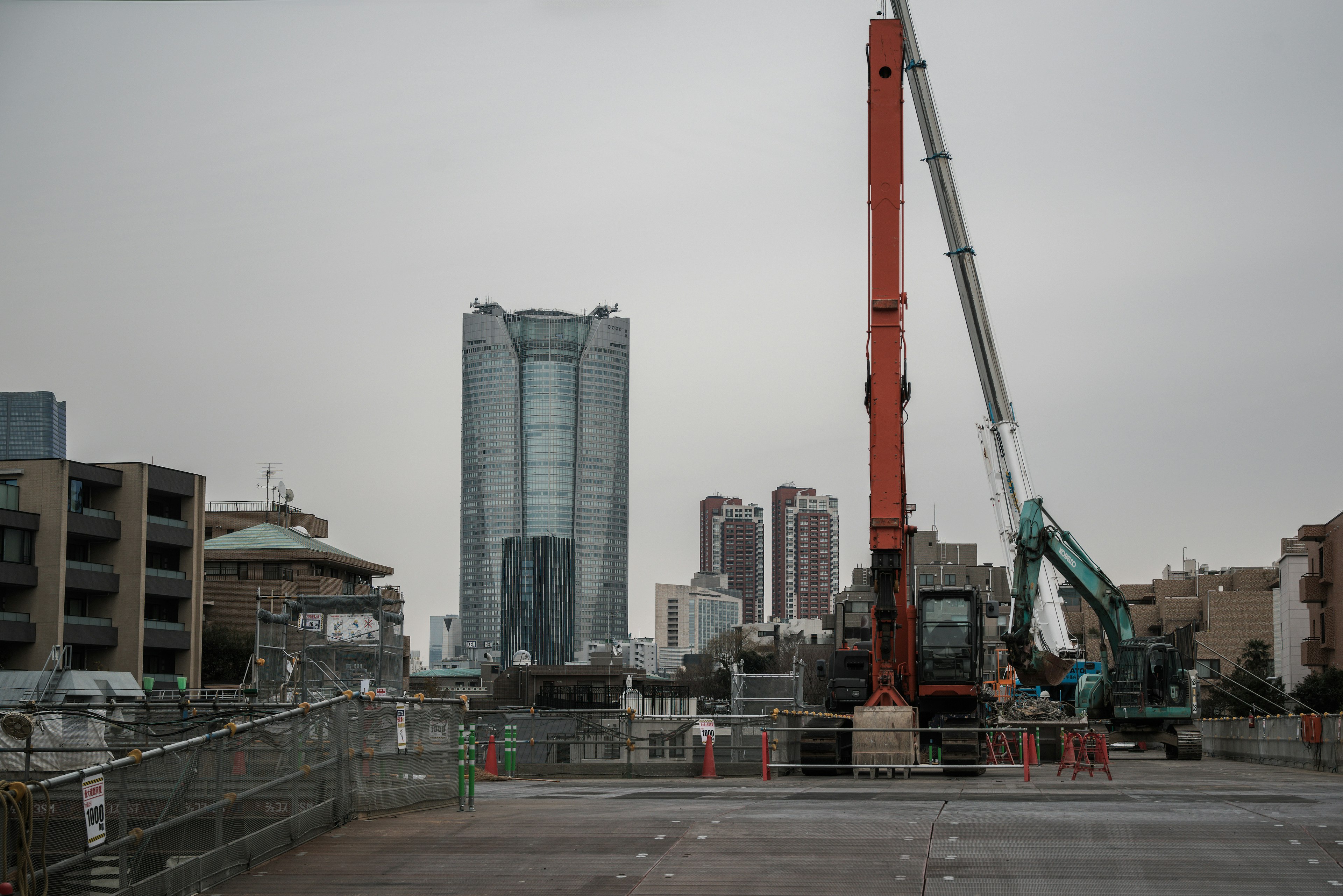 Site de construction avec des grues et des immeubles en arrière-plan