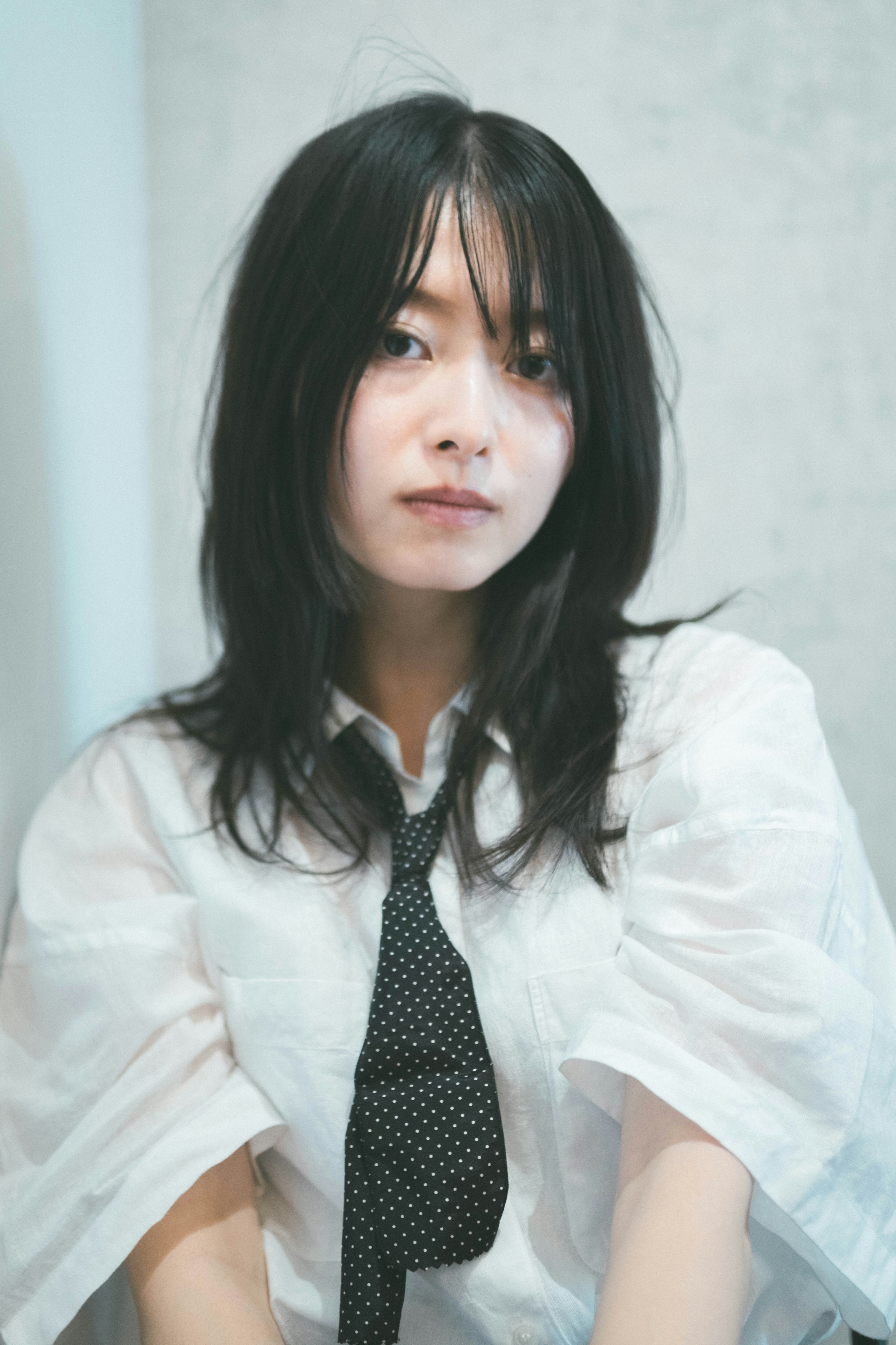 Young woman wearing a white shirt and black tie